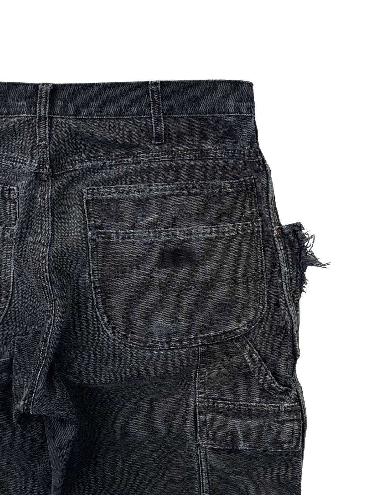 Rückseitige Carpenter-Tasche einer schwarzen Dickies Hose mit charakteristischen Verwaschungen und Vintage-Patina.