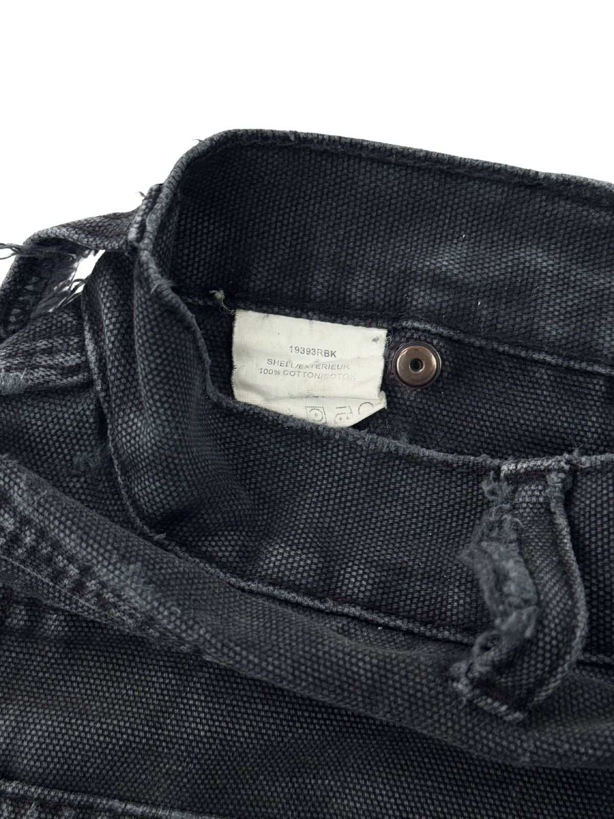 Weißes Pflegeetikett einer Vintage Dickies Hose aus 100% Baumwolle mit Produktcode und Waschhinweisen.