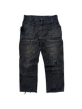 Vorderansicht einer thrashed Vintage Dickies Double Knee Hose in verwaschenem Schwarz mit starken Distressed-Details und Farbspritzern.