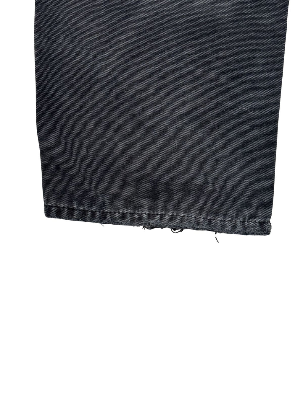 Detailansicht der abgenutzten Saumkante am linken Bein einer verwaschenen schwarzen Dickies Double Knee aus strapazierfähigem Baumwoll-Canvas.