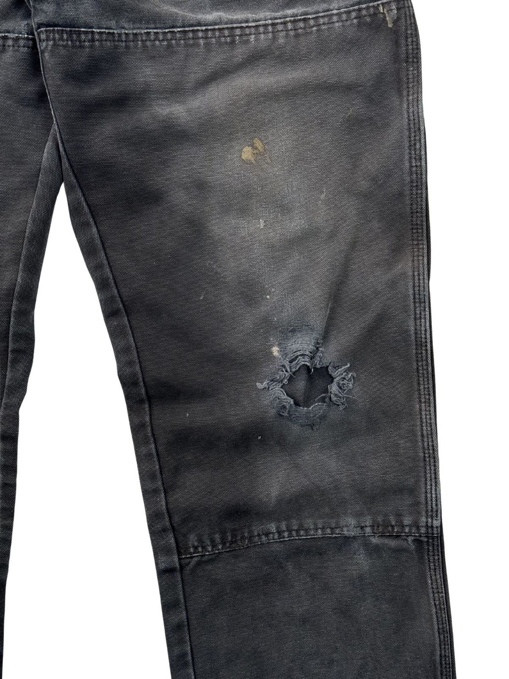 Nahaufnahme eines durchgescheuerten Lochs am Knie einer thrashed Dickies Double Knee Jeans.