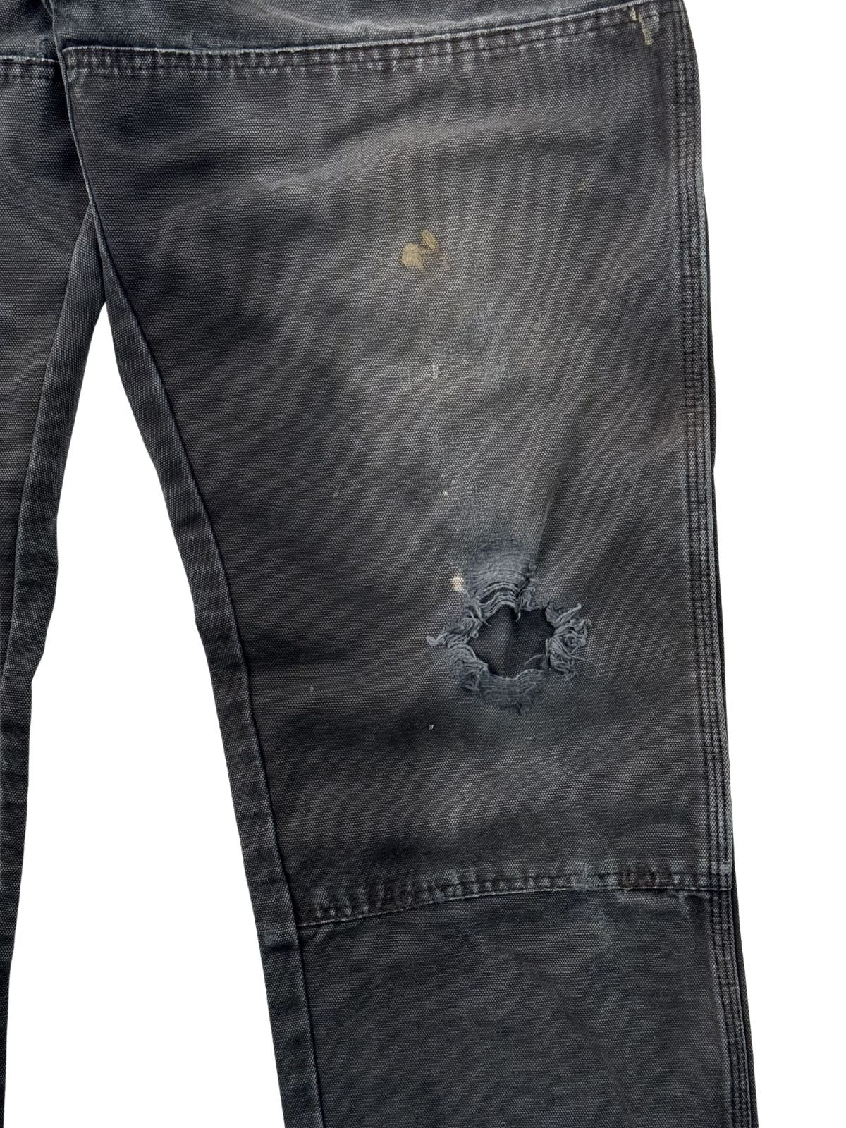 Nahaufnahme eines durchgescheuerten Lochs am Knie einer thrashed Dickies Double Knee Jeans.