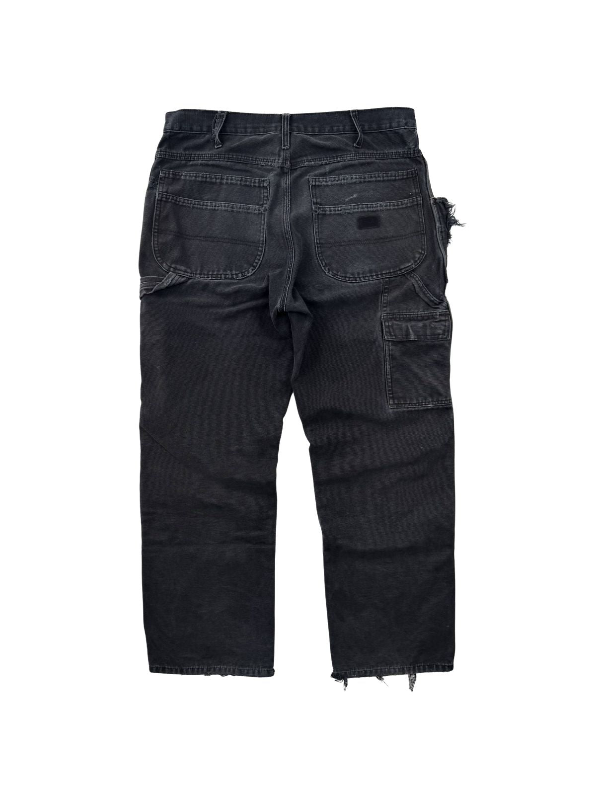 Rückansicht einer schwarzen Vintage Dickies Workwear Hose mit Carpenter-Taschen und authentischer Abnutzung im Streetwear-Look.