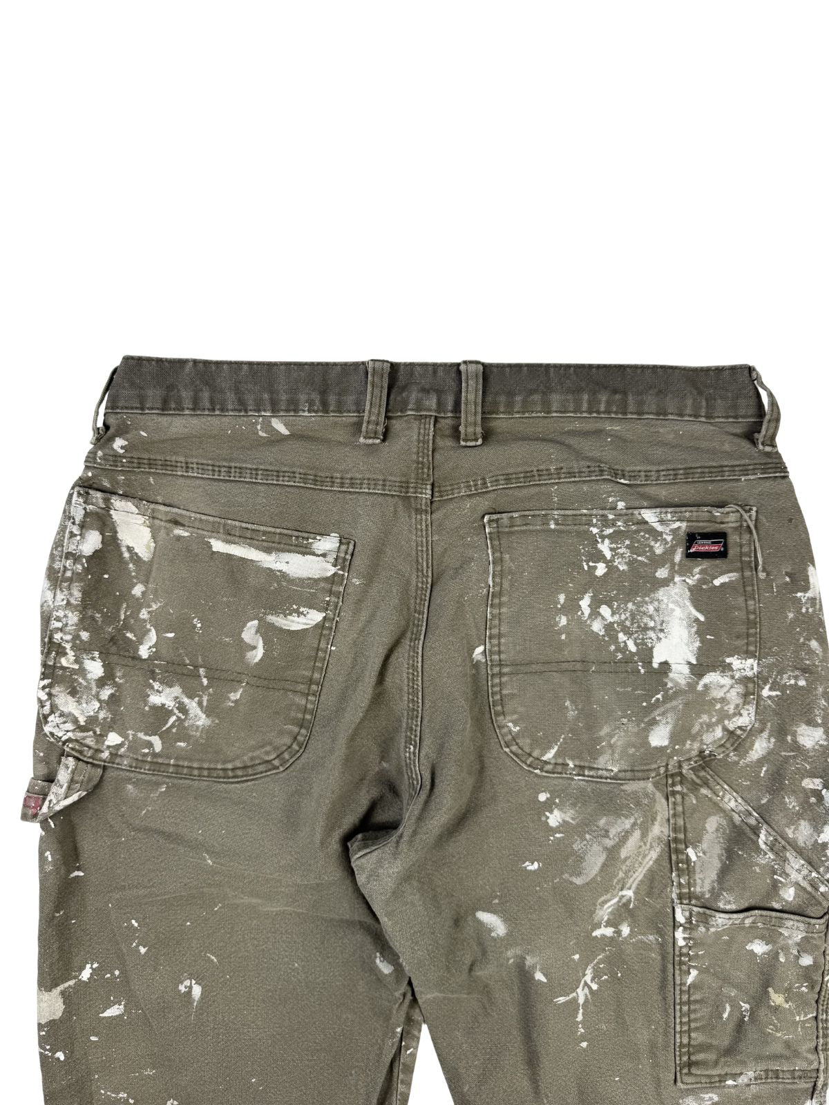 Detailaufnahme der hinteren Hüftpartie mit Fokus auf die beiden großen Gesäßtaschen, die über und über mit weißen Farbklecksen und Wischspuren überzogen sind.