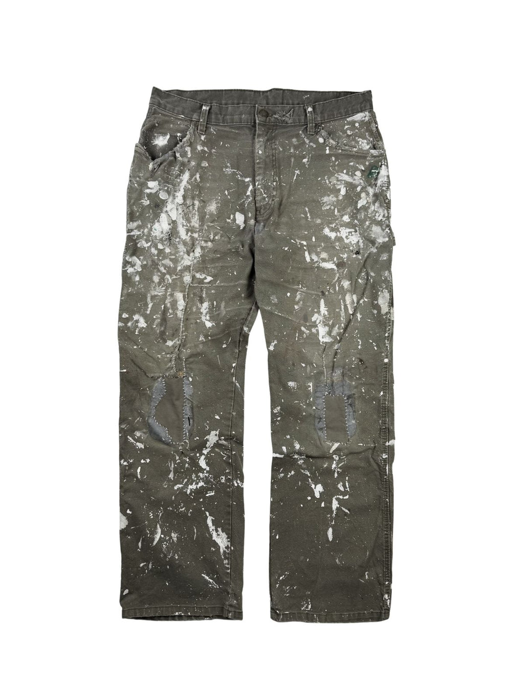 Komplettansicht der Vorderseite einer oliv-braunen Vintage Dickies Maler-Arbeitshose im Flatlay. Die Workwear-Hose zeigt extremen Distressed-Charakter mit intensiven weißen Farbspritzern und auffälligen, per Hand reparierten Flicken an beiden Knien. Flatlay auf weißem Hintergrund.
