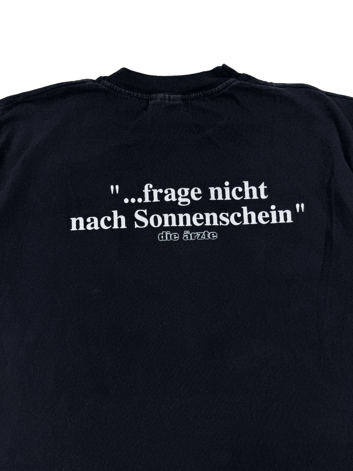 Detaillierte Nahaufnahme des weißen Backprints mit der Textzeile „...frage nicht nach Sonnenschein“ und dem dezenten „die ärzte“ Bandlogo.