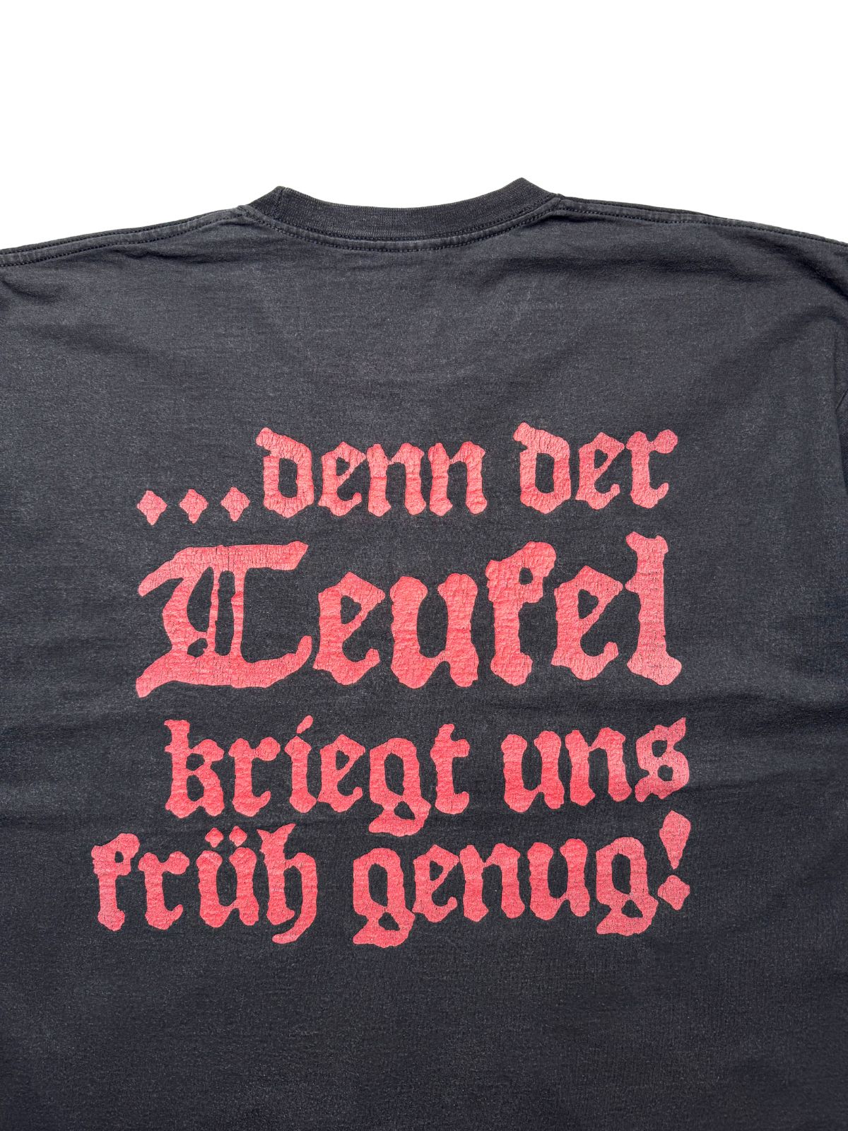 Detailansicht der oberen Rückseite mit Fokus auf den vierzeiligen roten Teufelsspruch in altdeutscher Frakturschrift.