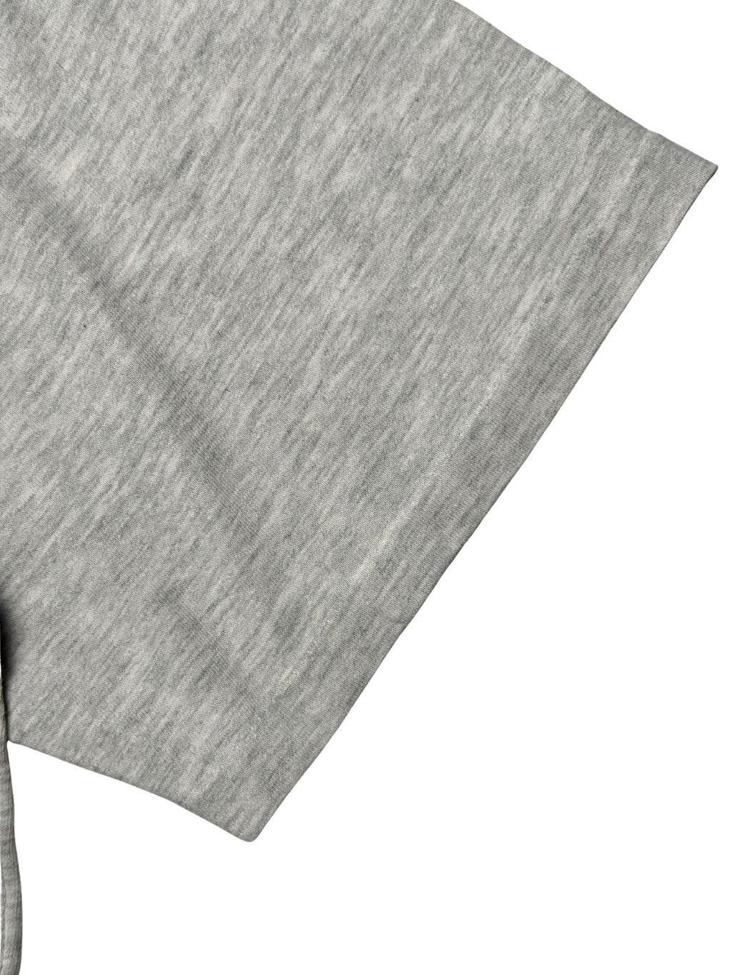 Detailansicht des kurzen Ärmelbunds mit klassischer Single-Stitch-Einfachnaht auf dem graumelierten Baumwollstoff.