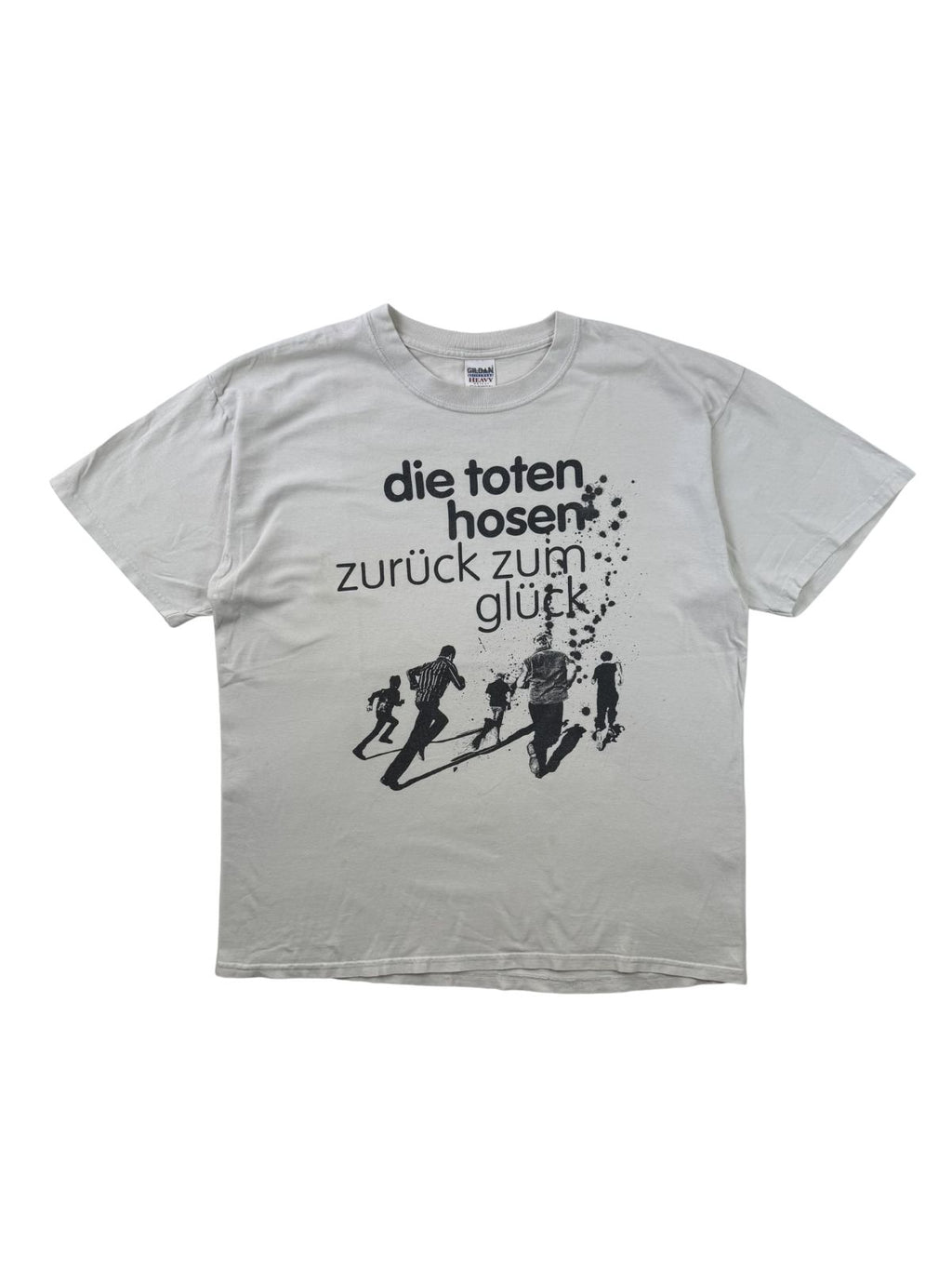 Komplettansicht der Vorderseite eines hellgrauen Vintage Band-T-Shirts von Die Toten Hosen zum Album „Zurück zum Glück“ aus dem Jahr 2004. Flatlay auf weißem Hintergrund.