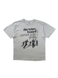 Komplettansicht der Vorderseite eines hellgrauen Vintage Band-T-Shirts von Die Toten Hosen zum Album „Zurück zum Glück“ aus dem Jahr 2004. Flatlay auf weißem Hintergrund.