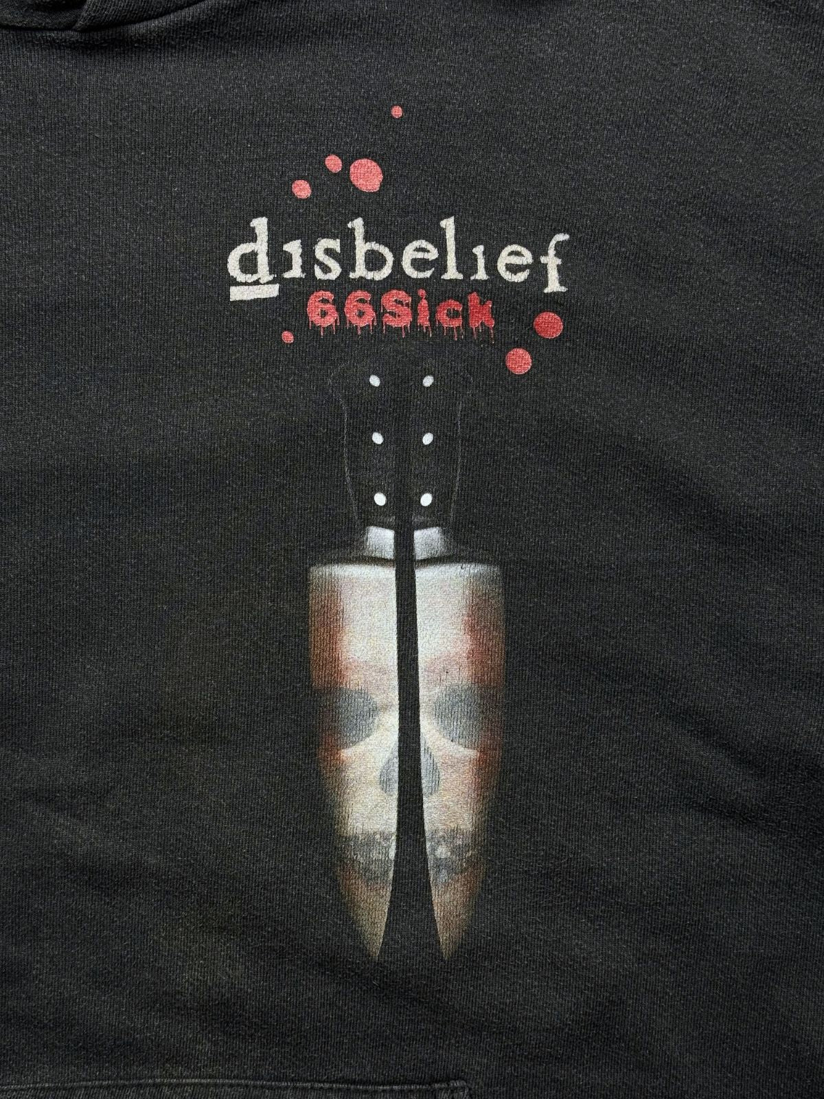 Nahaufnahme des Brustprints mit Blutstropfen-Grafik, dem Bandnamen „disbelief 66Sick“ und der Messer-Illustration.