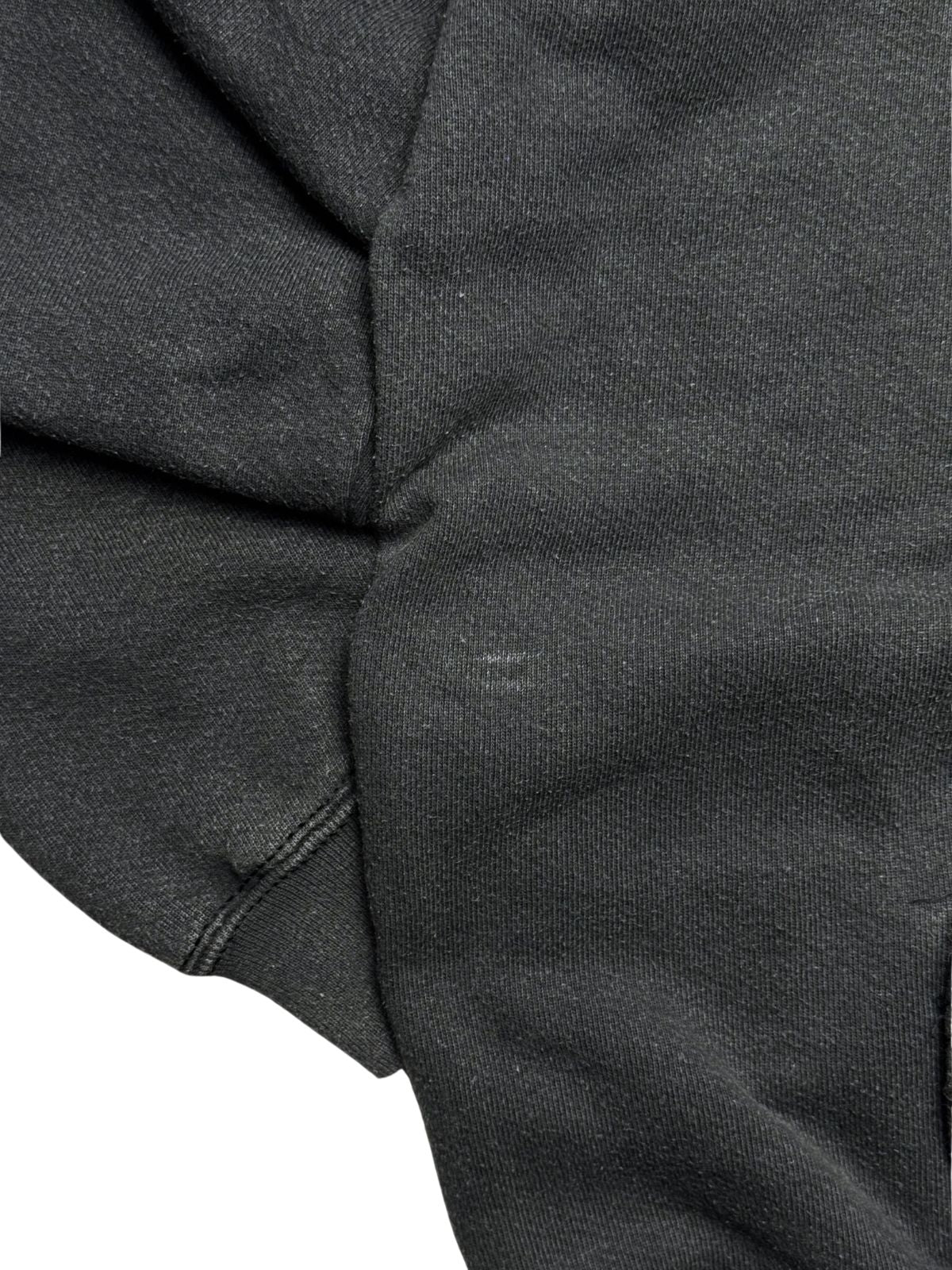 Nahaufnahme des Sweatshirt-Stoffs im Bereich des Ärmelbündchens zur transparenten Zustandsdokumentation mit einer leichten, hellen Ausbleichung / Fleck.