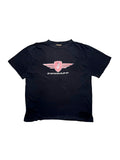 Originales schwarzes Vintage Zündapp T-Shirt aus den 1990er Jahren in der vorderen Gesamtansicht. Kultiges Biker-/Mofa-Motivshirt im Thrashed-Look mit rosa Zündapp-Flügel-Logo und großen Löchern am Saum.