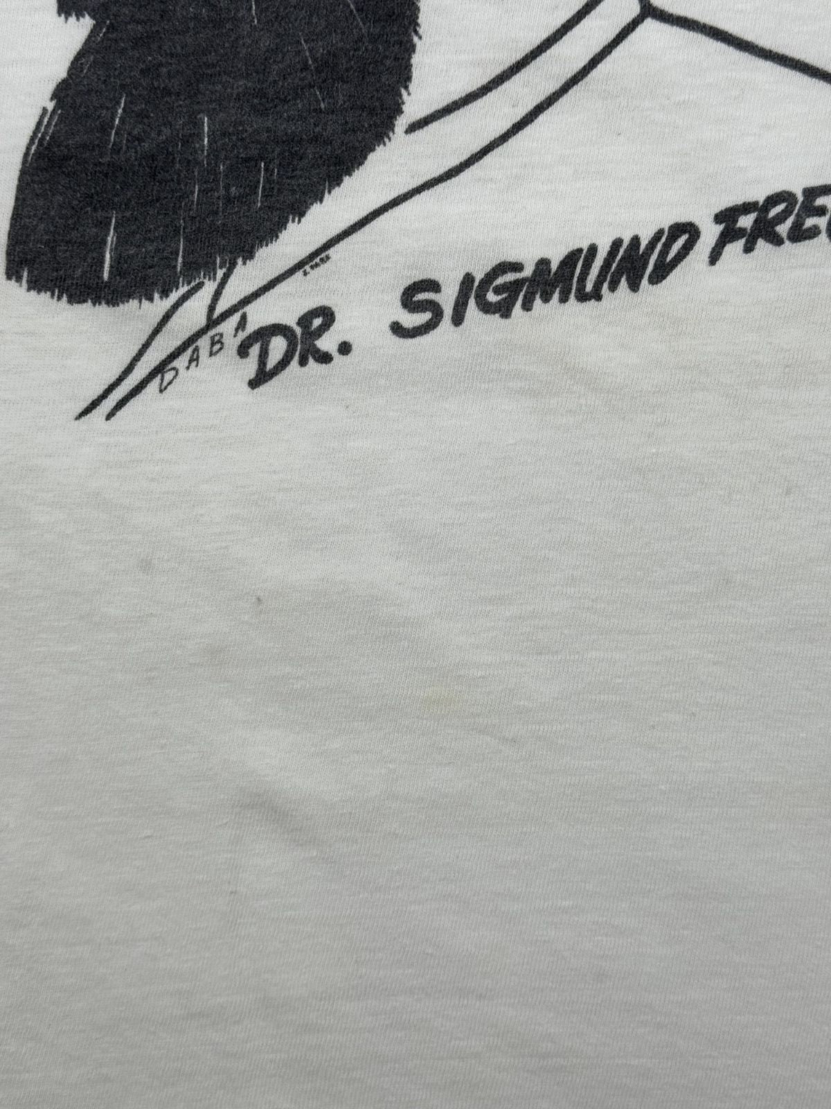 Makroaufnahme unterhalb der Grafik mit dem Künstlernamen bzw. der Signatur „DABA“ neben dem gedruckten Schriftzug „DR. SIGMUND FREUD“.
