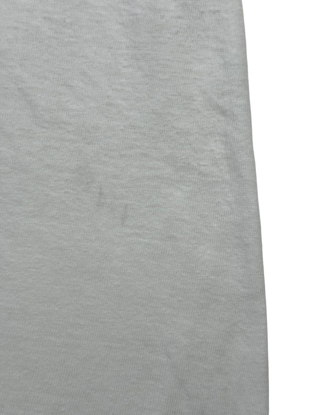 Nahaufnahme einer feinen, vertikal verlaufenden Verfärbung bzw. Spur auf dem weißen Baumwollmaterial der Rückseite.
