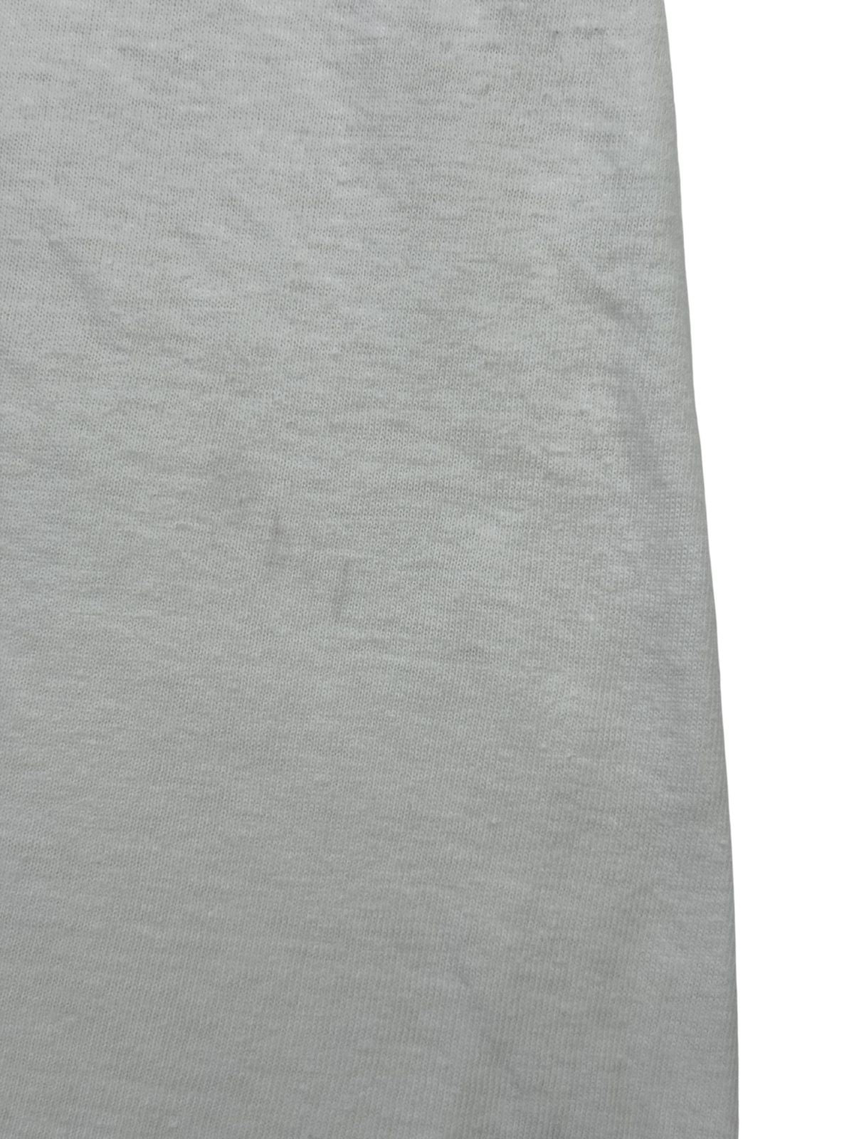 Nahaufnahme einer feinen, vertikal verlaufenden Verfärbung bzw. Spur auf dem weißen Baumwollmaterial der Rückseite.