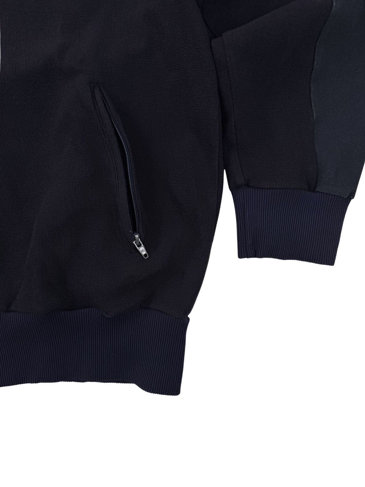 Detailansicht der Reißverschlusstasche und der elastischen Rippstrickbündchen an Ärmeln und Saum der Vintage-Jacke.