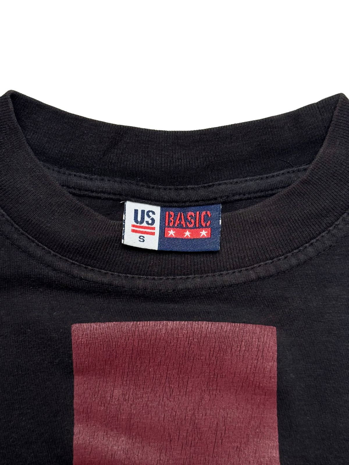 Nahaufnahme des Nackenbereichs mit dem originalen, gut erhaltenen Stoffetikett der Marke „US BASIC“ in Größe S.