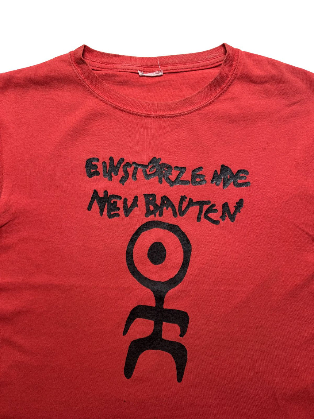 Detailansicht der oberen Vorderseite mit Fokus auf den schwarzen „EINSTÜRZENDE NEUBAUTEN“-Print und das symbolische Strichmännchen-Logo auf dem roten Baumwollstoff.