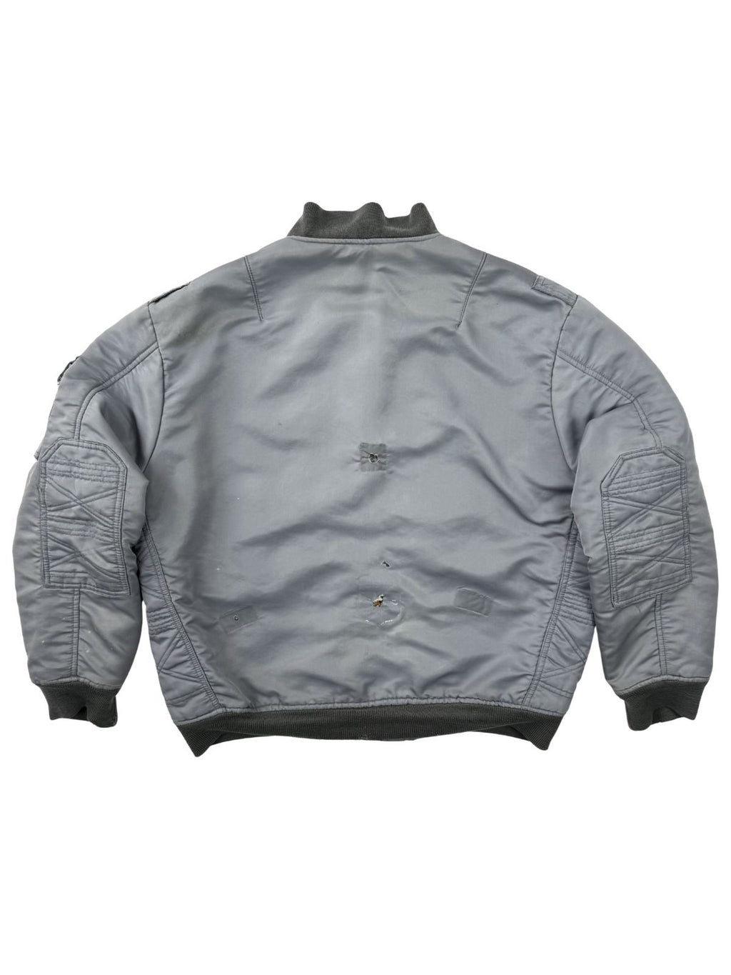Rückansicht der vintage Fliegerjacke; zeigt das starke Sun-Fading und mehrere authentische Löcher im Stoff, die den distressed Charakter betonen.