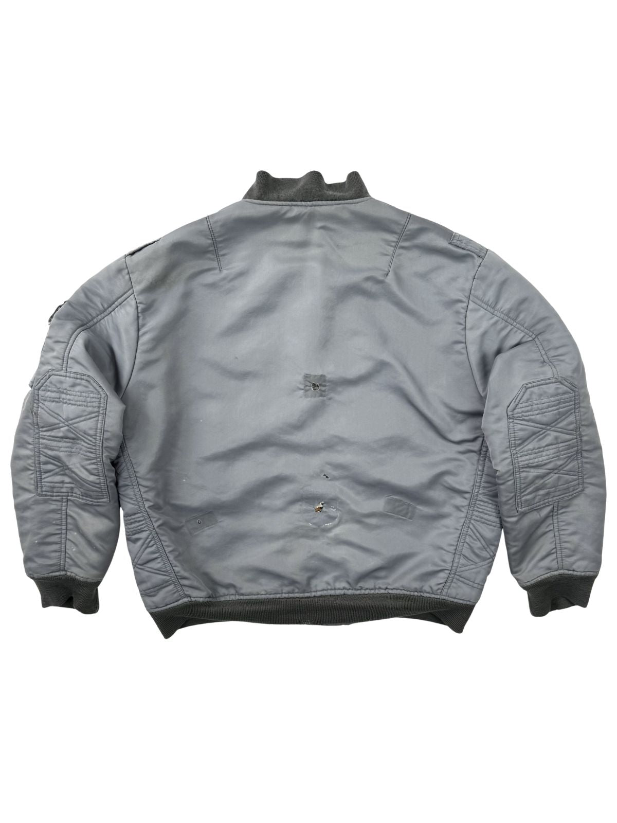 Rückansicht der vintage Fliegerjacke; zeigt das starke Sun-Fading und mehrere authentische Löcher im Stoff, die den distressed Charakter betonen.