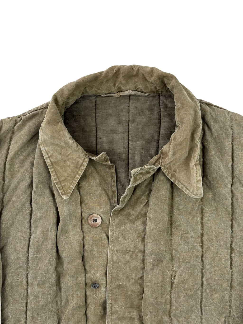 Detailansicht des oberen Frontbereichs der Militärjacke. Zu sehen ist der geöffnete Umlegekragen aus robustem, verwaschenem Baumwoll-Canvas sowie die Knopfleiste mit einem angenähten, braunen Kunststoffknopf.