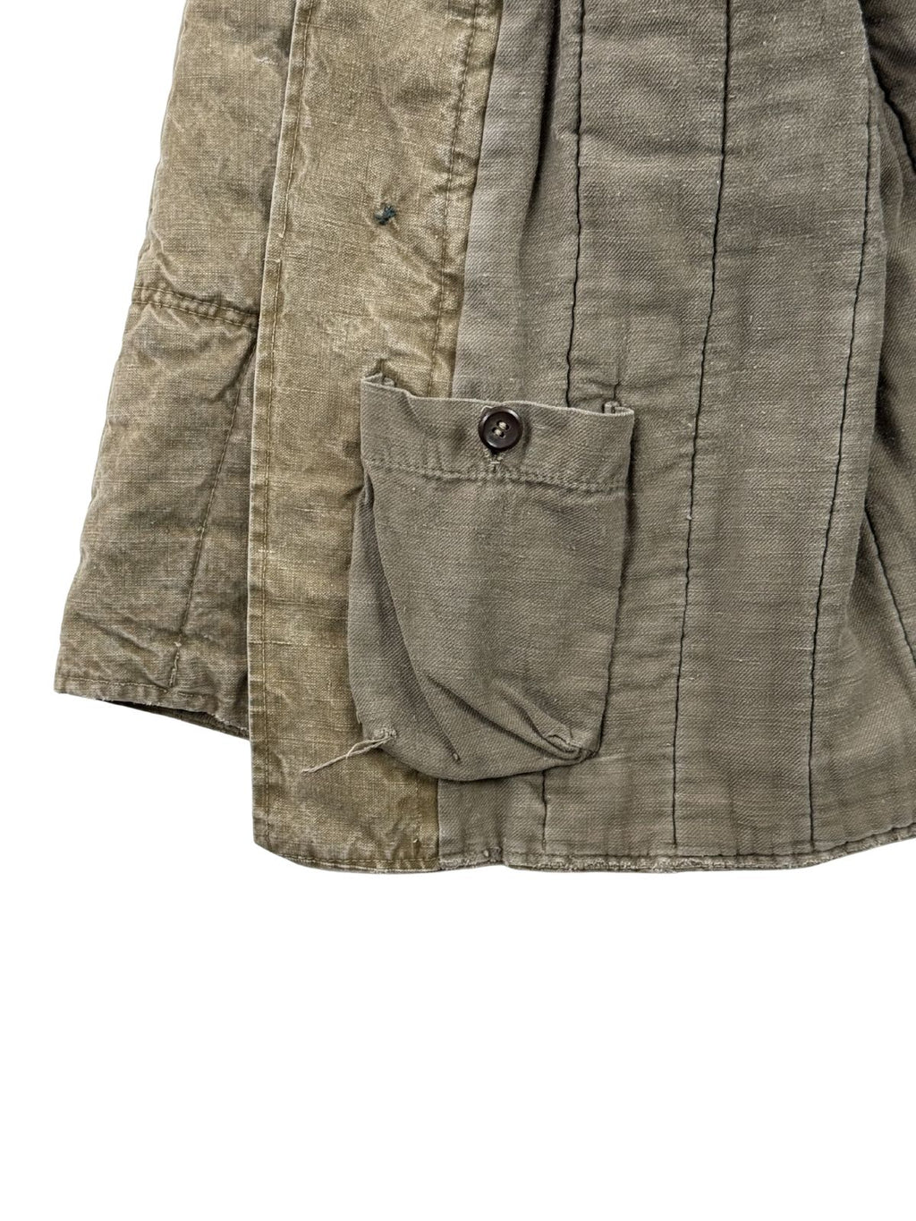 Nahaufnahme der unteren rechten Innenseite der UdSSR-Militärjacke mit einer kleinen, per Knopf verschließbaren Zusatztasche (Verbandtasche / Uhrentasche) am Saum.