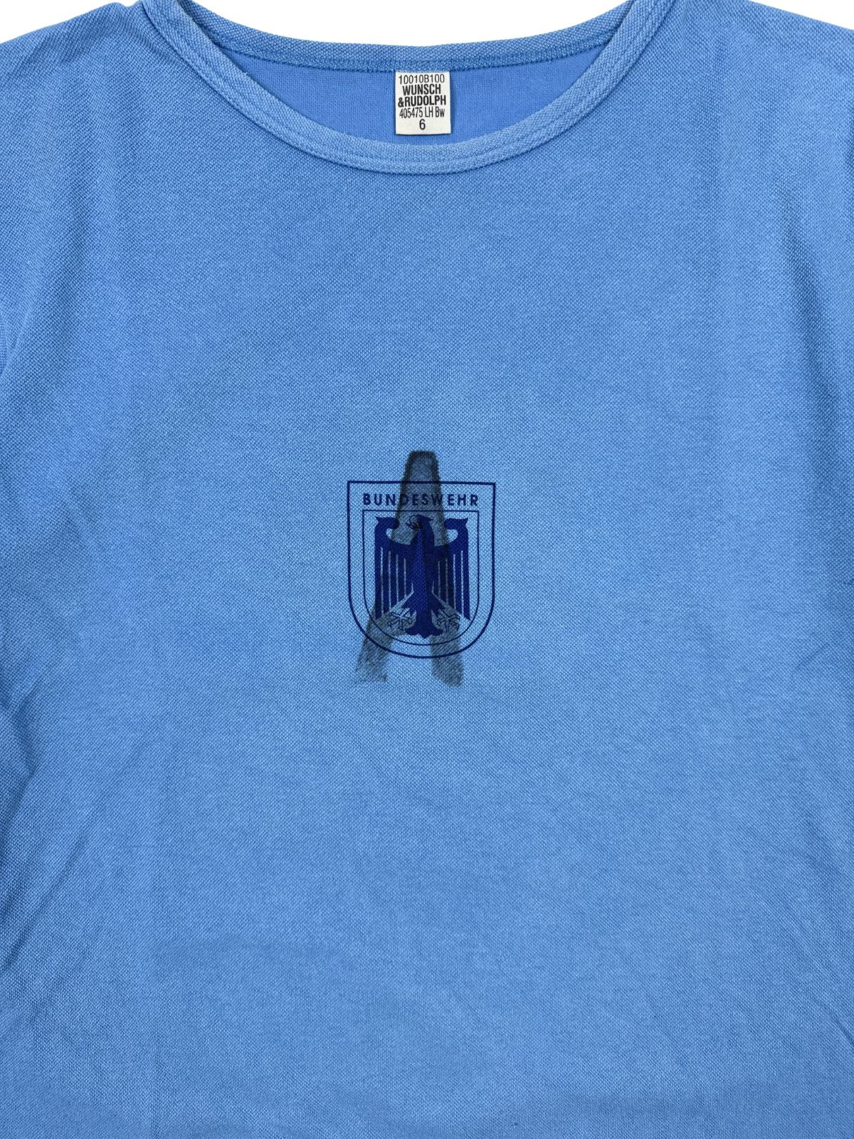 Hochauflösende Detailansicht des dunkelblauen Brustprints; zeigt den Bundesadler im Stil einer Sports-Crest mit dem Text „BUNDESWEHR“ auf hellblauem Grund und dem "A" Stempel für ausgemustert.