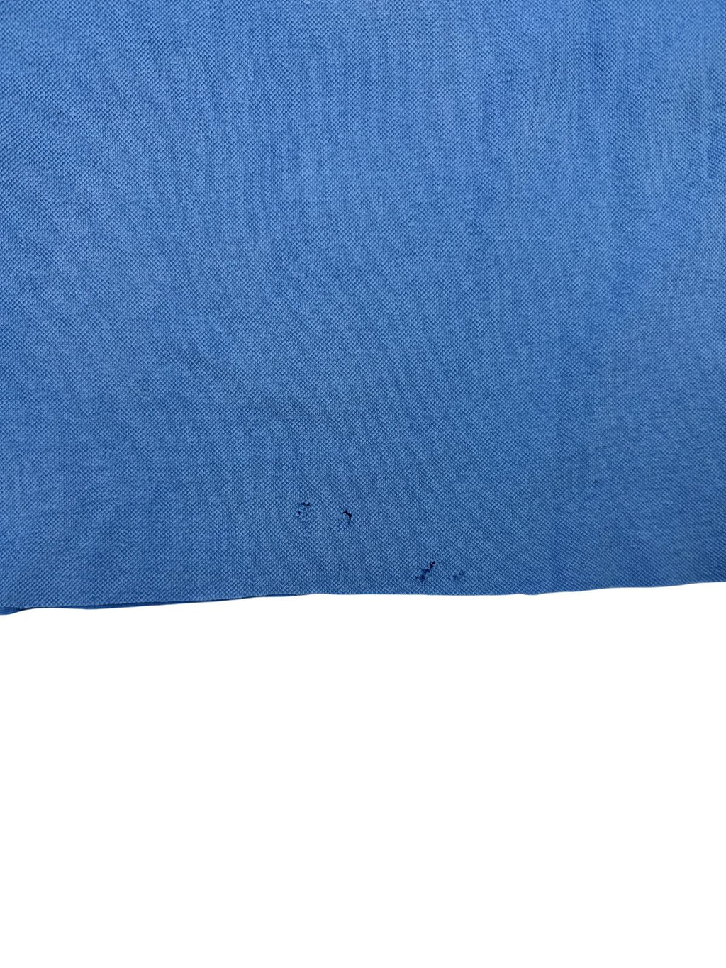 Transparente Nahaufnahme mehrerer kleiner Löcher (Pinholes) im unteren Saumbereich; ein Zeichen für den authentischen, gebrauchten Vintage-Zustand.