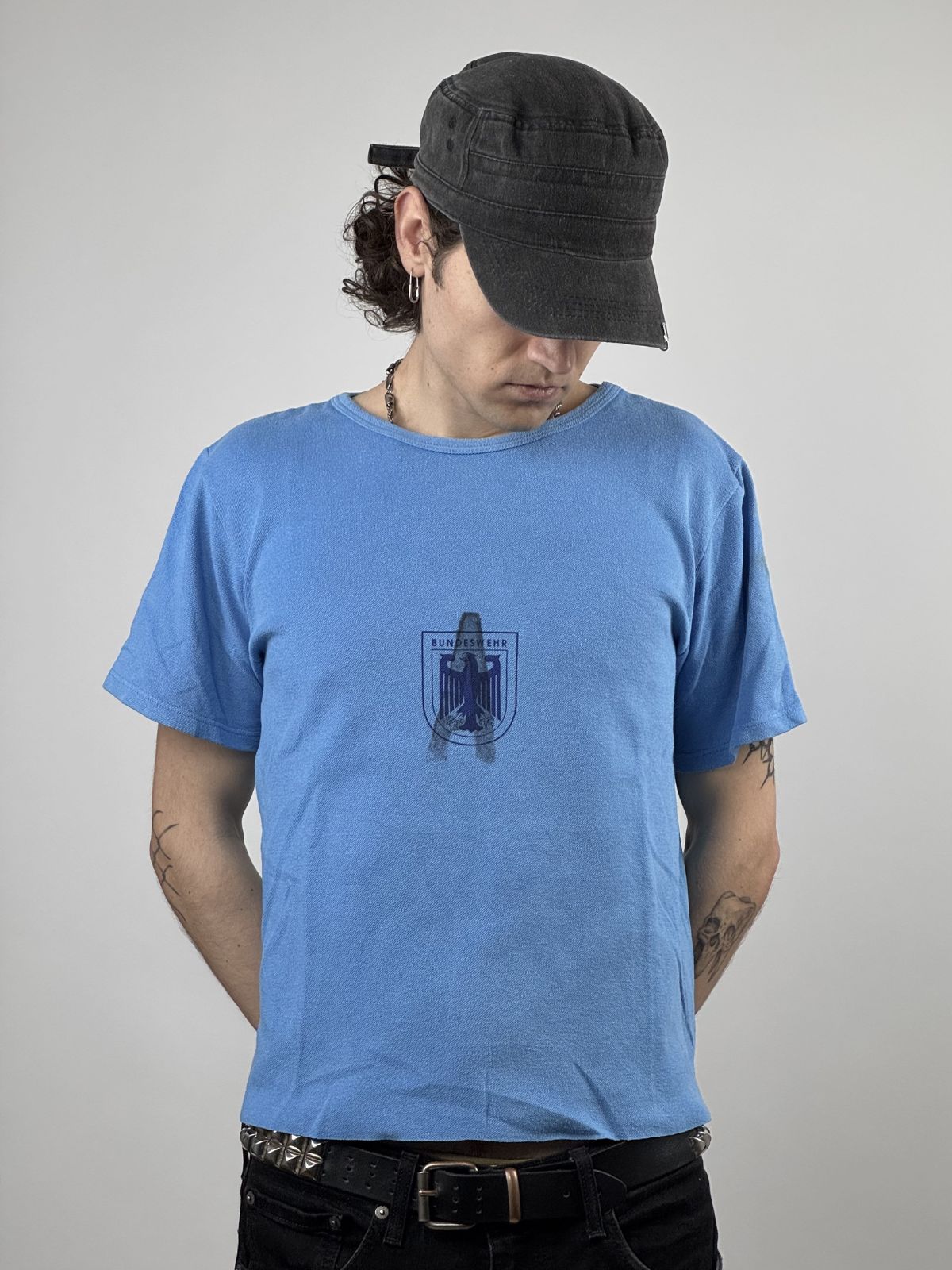 Vorderansicht eines hellblauen Vintage Bundeswehr Sport-T-Shirts aus den 1980ern mit einem dunkelblauen Brustprint, der den Bundesadler in einem Wappen zeigt.