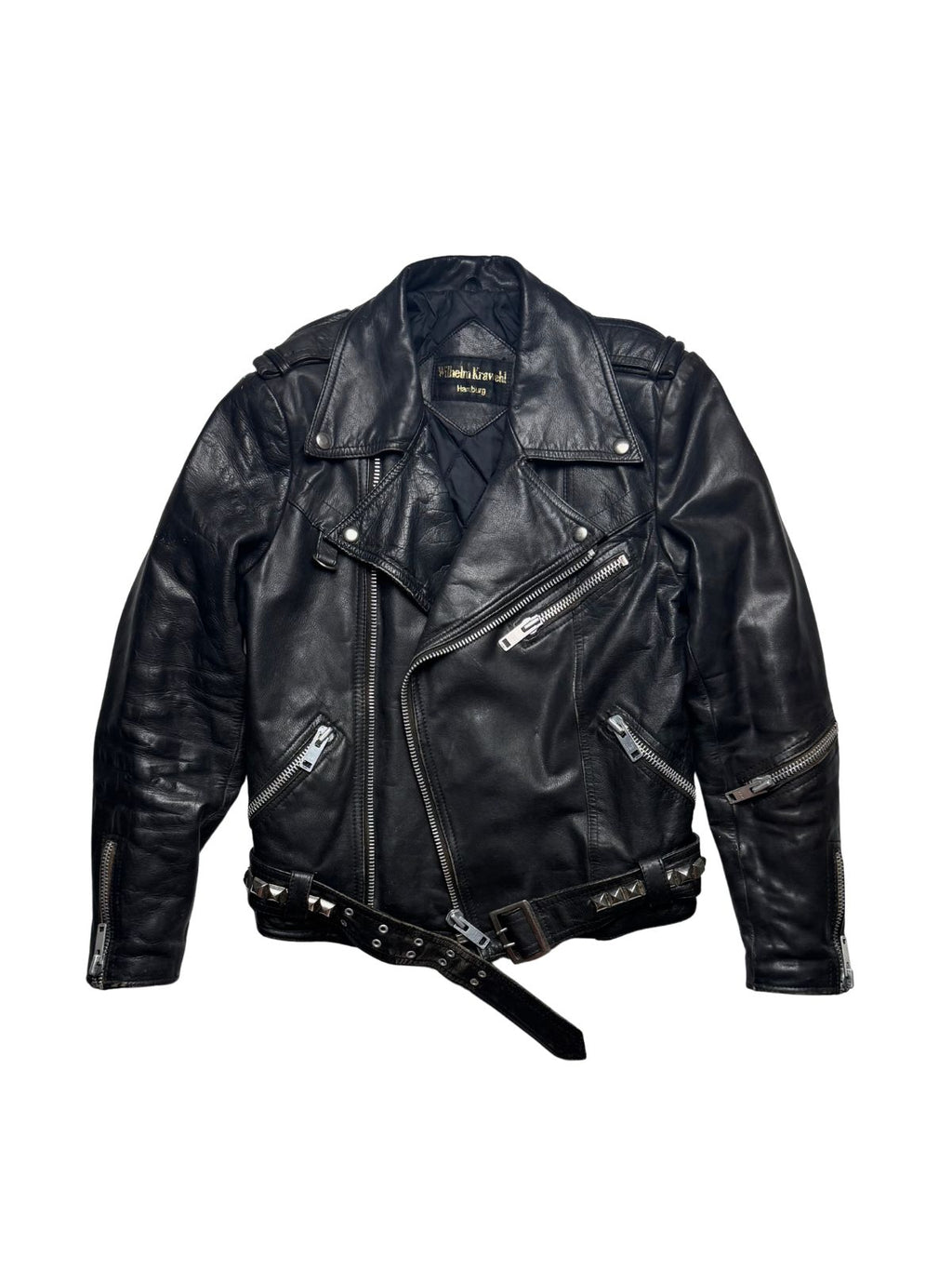 Deutsche Vintage Punk-Lederjacke aus den 1980er Jahren von Wilhelm Krawehl Hamburg in der vorderen Gesamtansicht mit verstellbarem Nietengürtel und asymmetrischem Reißverschluss.