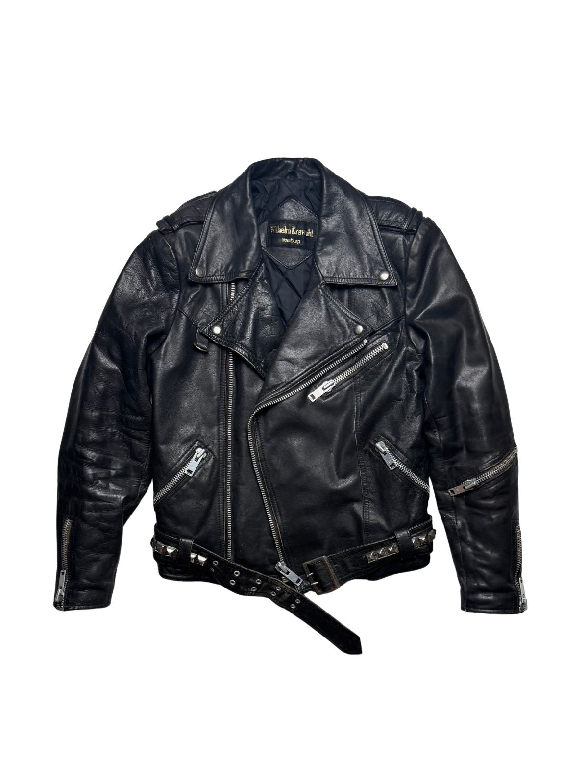 Deutsche Vintage Punk-Lederjacke aus den 1980er Jahren von Wilhelm Krawehl Hamburg in der vorderen Gesamtansicht mit verstellbarem Nietengürtel und asymmetrischem Reißverschluss.