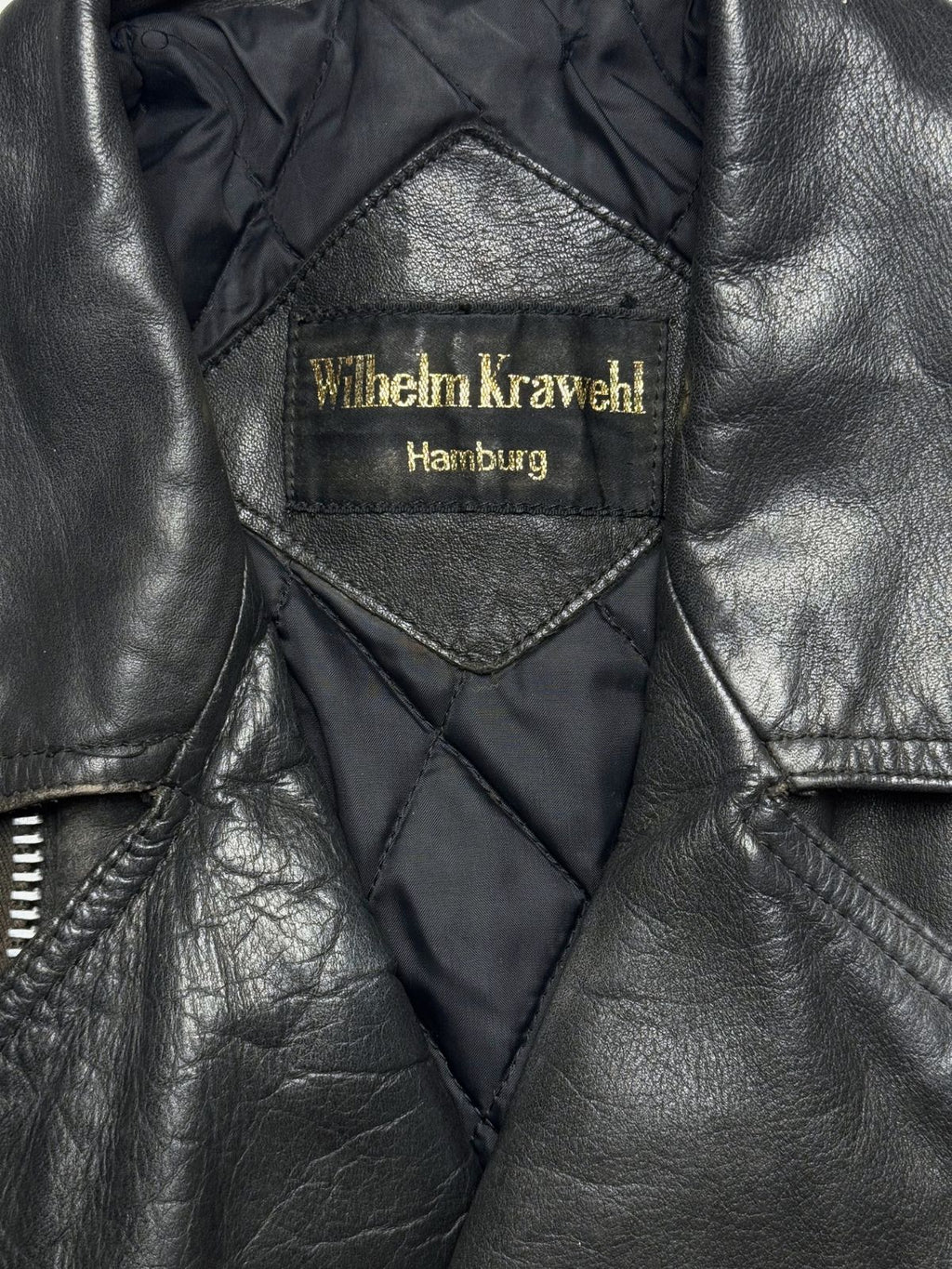 Nahaufnahme des inneren Kragenbereichs mit dem gewebten, gold-gestickten Markenetikett „Wilhelm Krawehl Hamburg“ auf dem rautenförmigen Leder-Patch.