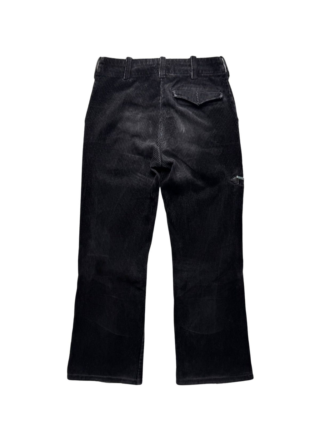 Rückseite der schwarzen Cord-Zunfthose in der Gesamtansicht mit Gürtelschlaufen, geknöpfter Gesäßtasche mit Patte und leicht ausgewaschenen Abnutzungsspuren im Gesäßbereich.