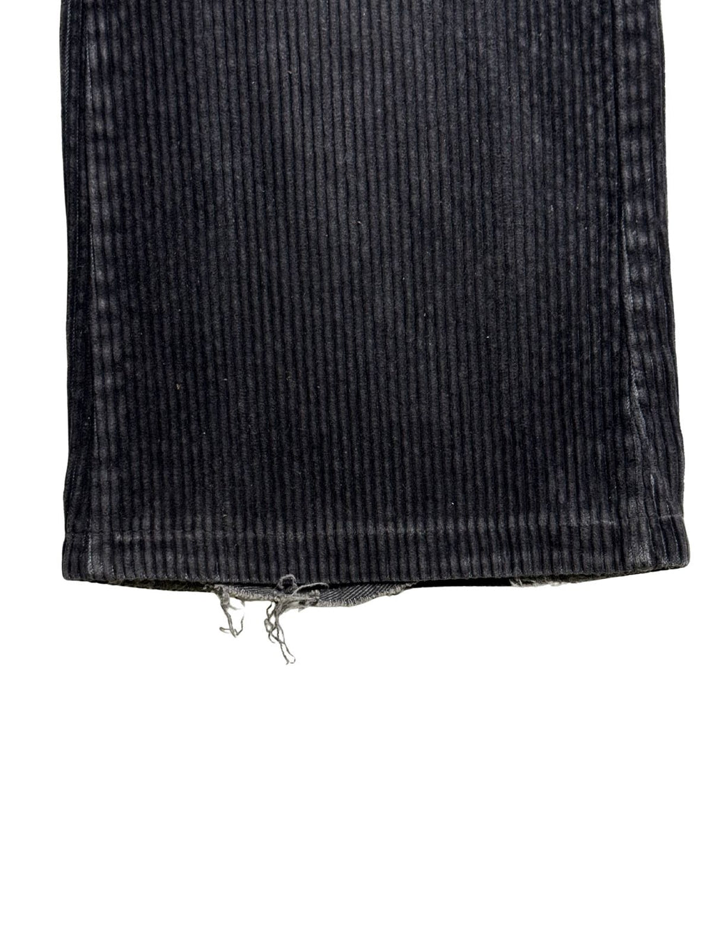 Detailaufnahme des unteren Hosenbein-Saums mit ausgefransten Fäden und Tragespuren (Heel Bite) an der Hinterkante.