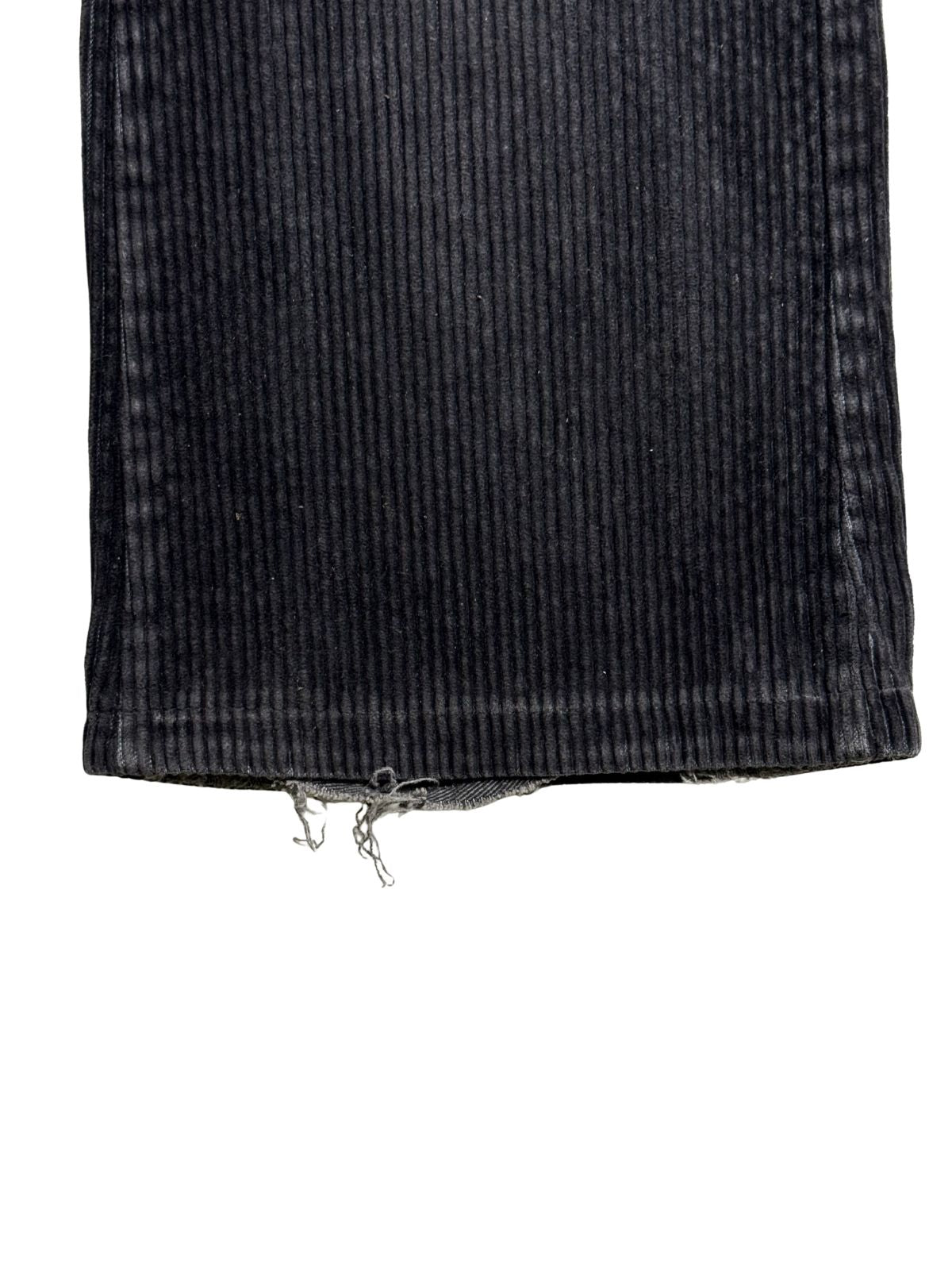 Detailaufnahme des unteren Hosenbein-Saums mit ausgefransten Fäden und Tragespuren (Heel Bite) an der Hinterkante.