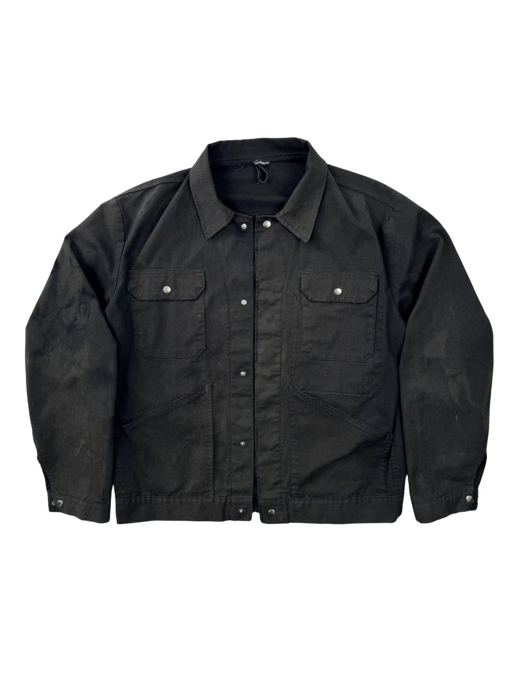 Vorderseite einer schwarzen Vintage German Workwear Jacke aus Baumwoll-Canvas; zeigt den boxy Schnitt, Brusttaschen und die verwaschene schwarze Farbe.