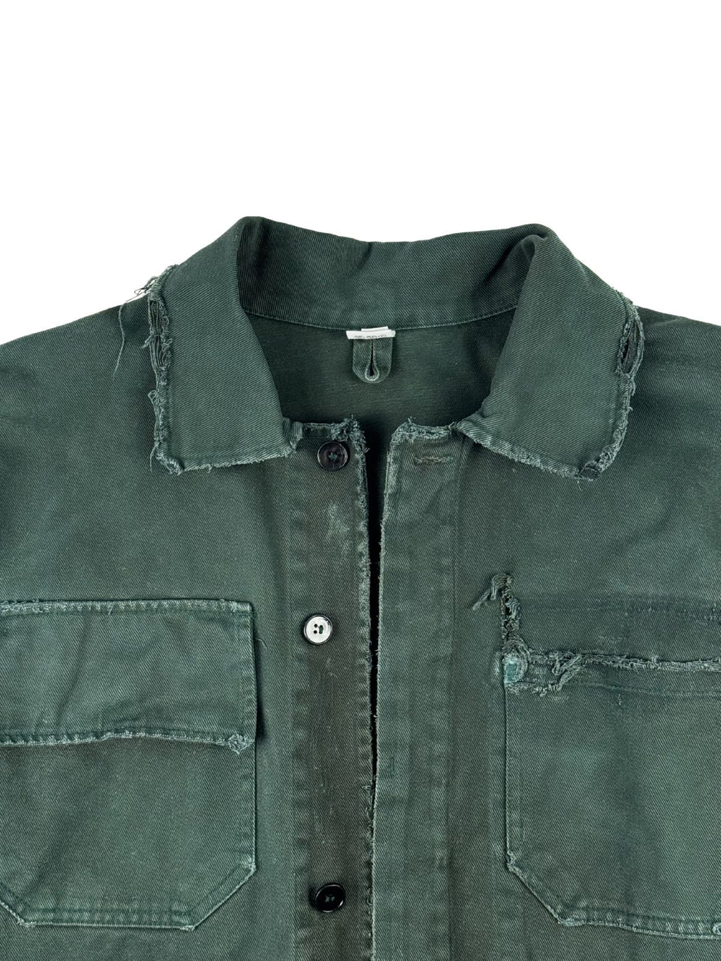 Detailansicht der oberen Vorderseite der grünen Canvas-Arbeitsjacke mit Blick auf die Knopfleiste, den distressed Kragen und die beiden aufgesetzten Brusttaschen.
