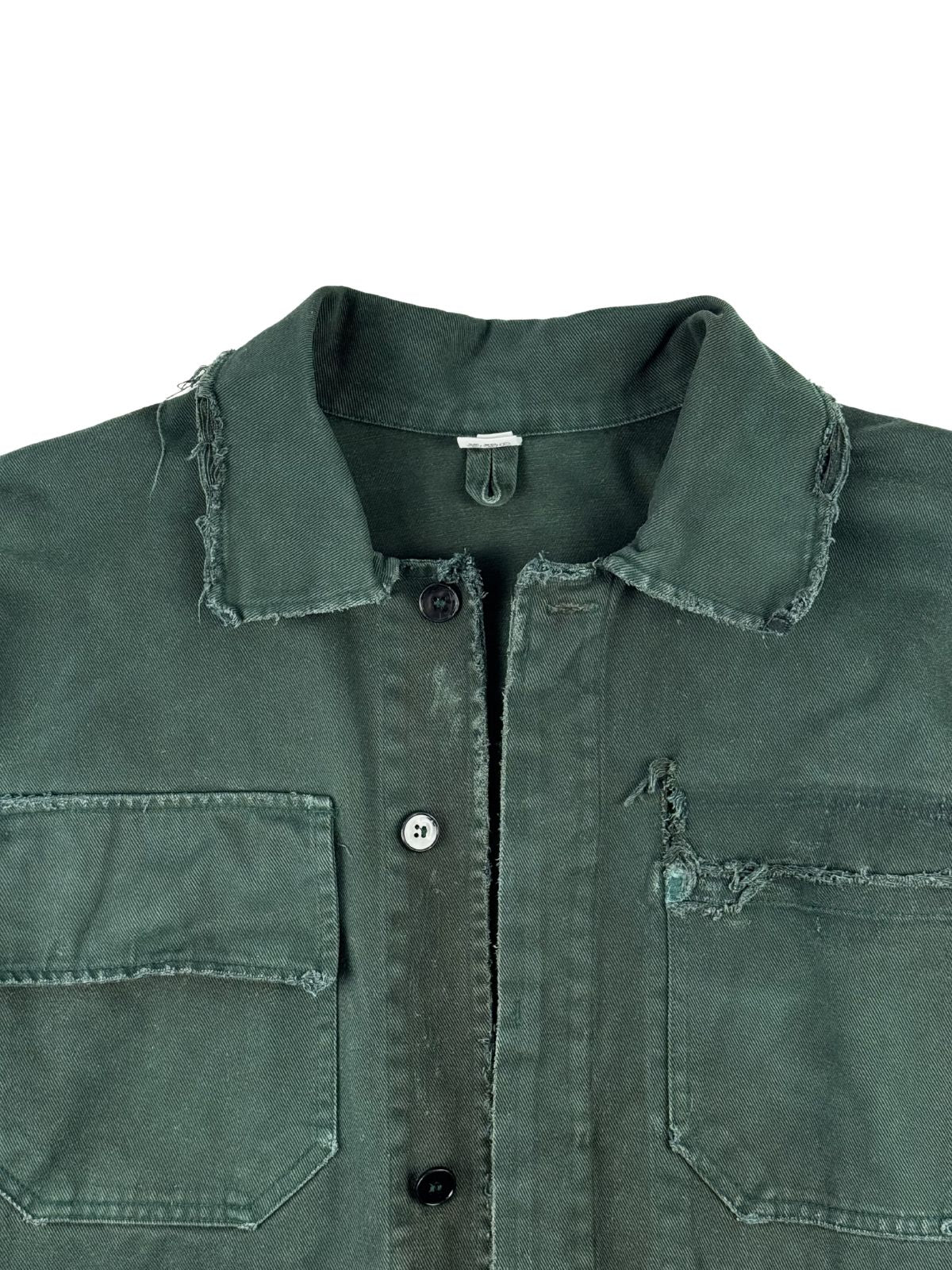 Detailansicht der oberen Vorderseite der grünen Canvas-Arbeitsjacke mit Blick auf die Knopfleiste, den distressed Kragen und die beiden aufgesetzten Brusttaschen.