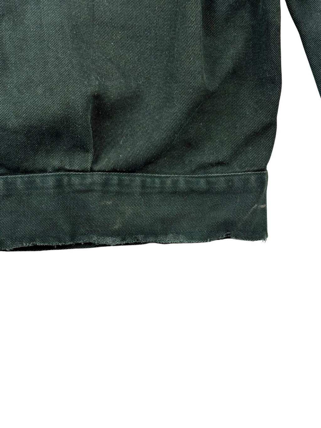Detailansicht des hinteren unteren Saums der Arbeitsjacke, die das authentische Fading an den Kanten sowie leichte, altersbedingte Fransen am Jackenbund zeigt.