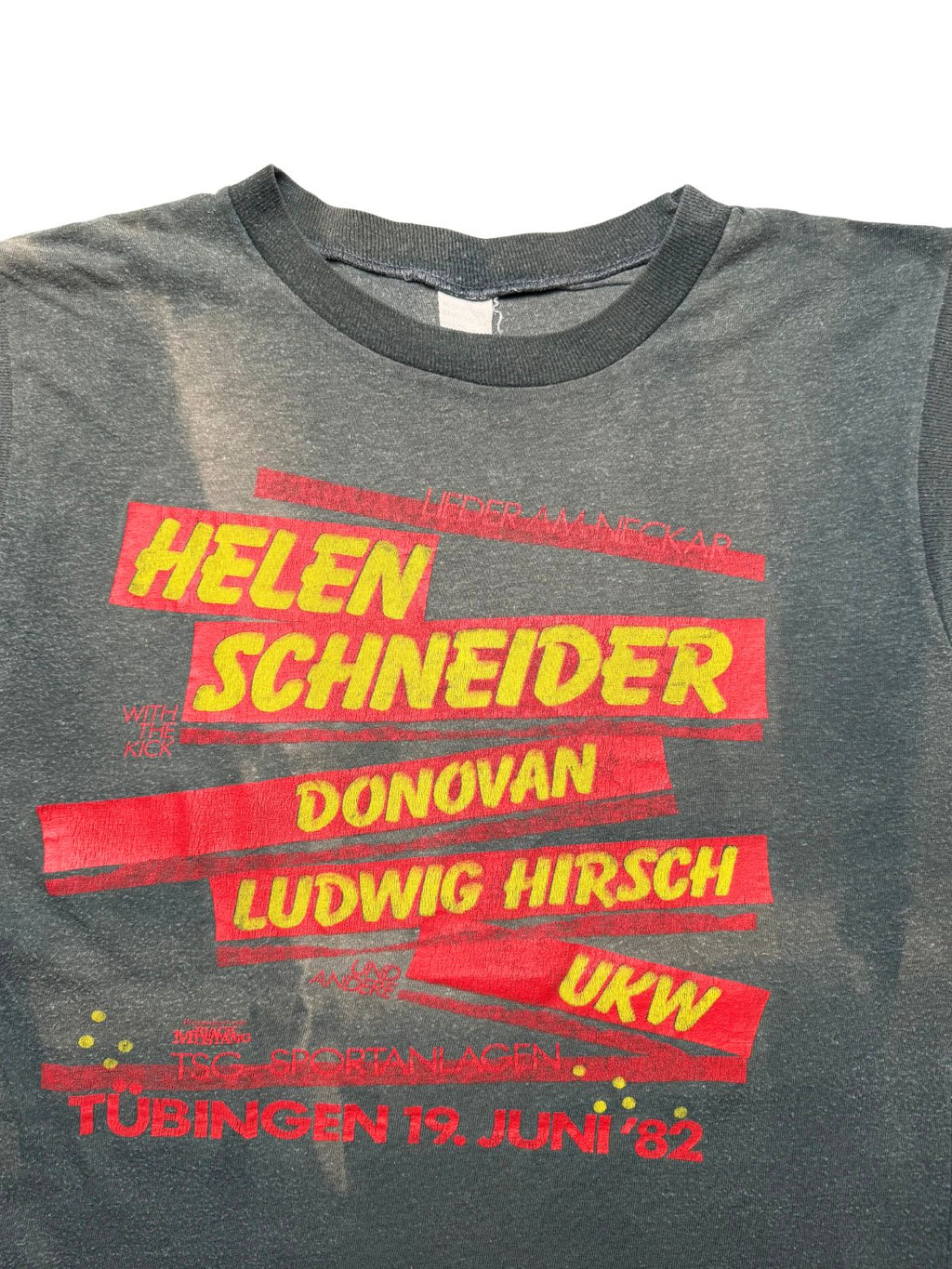 Detailansicht der vorderen Brustpartie mit geripptem Rundhalsausschnitt und dem rot-gelben Festival-Aufdruck (Helen Schneider, Donovan, Ludwig Hirsch, UKW, TSG-Sportanlagen Tübingen 19. Juni ’82).