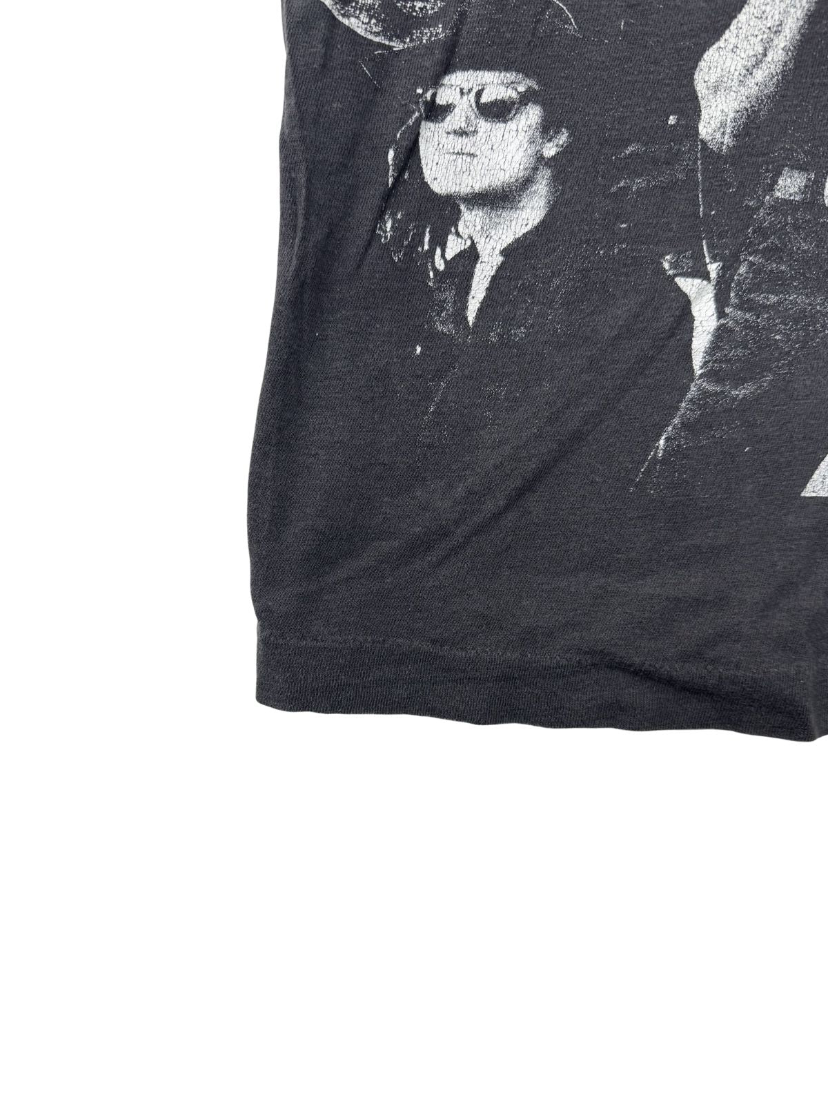 Nahaufnahme des unteren Saums des T-Shirts; zeigt die authentische Einzelnaht (Single Stitch) auf dem verwaschenen schwarzen Baumwollstoff.