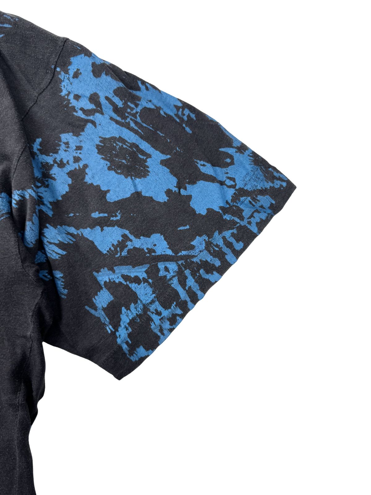 Detailansicht des Ärmels mit blauem „Cloud-Print“-Muster und sichtbarer „Single Stitch“ Naht (Einzelnaht), typisch für 90er Jahre Vintage-Merchandise.