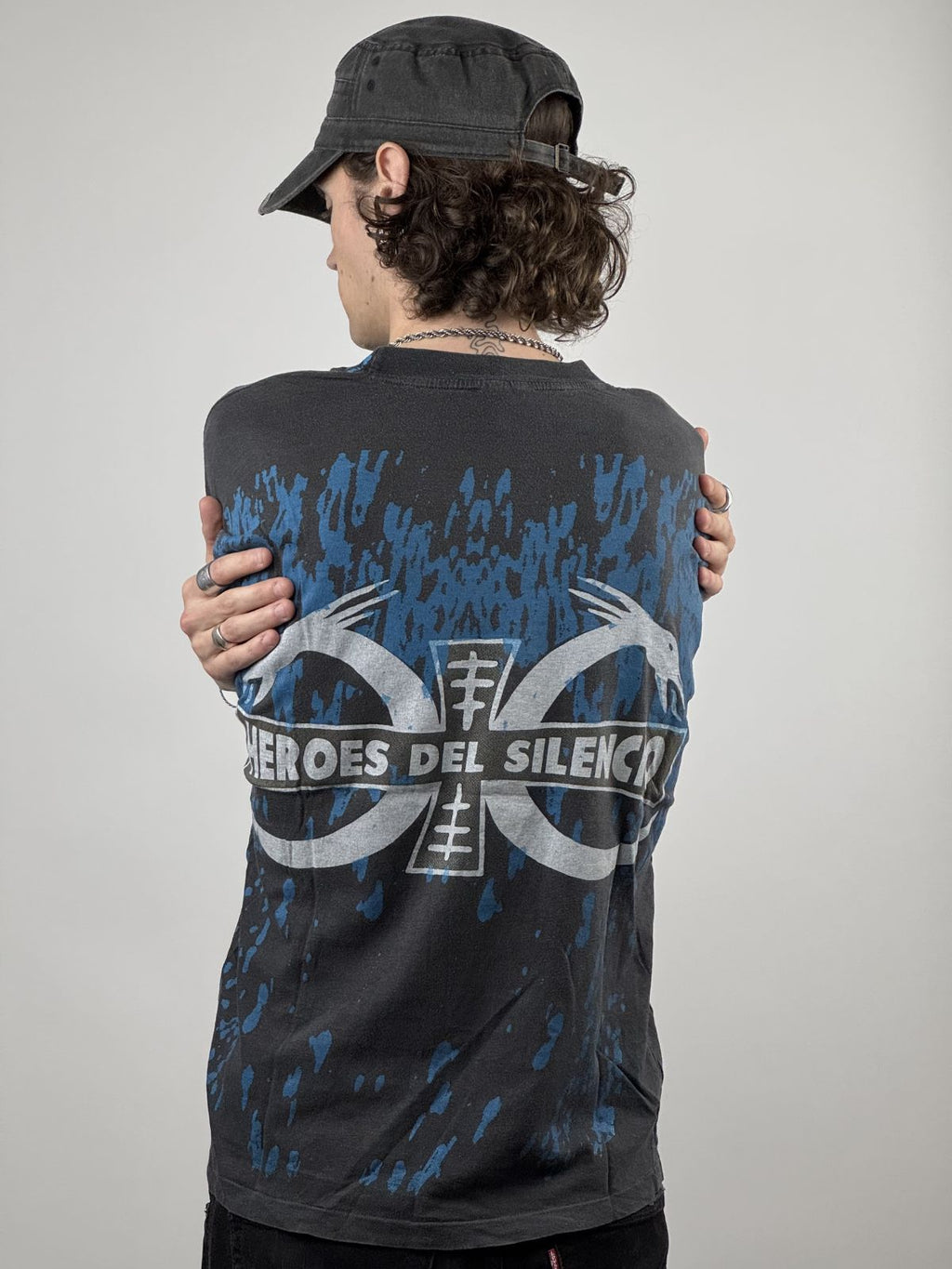 Rückansicht des getragenen Band-Shirts; zeigt das markante Rückenlogo und die Kombination mit einer schwarzen Streetwear-Mütze.
