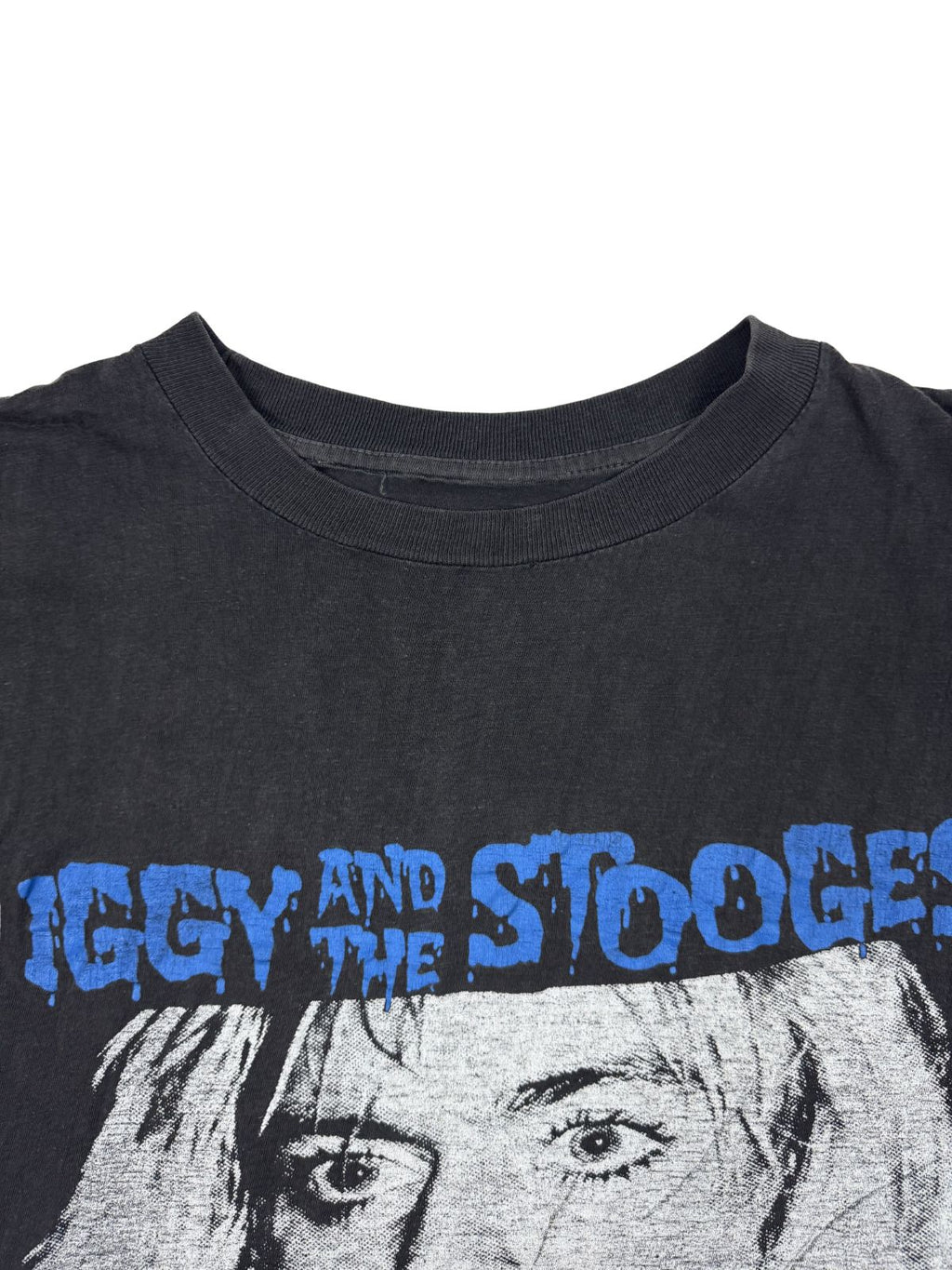 Nahaufnahme des Rundhalsausschnitts des Vintage-Shirts; zeigt die Textur des Baumwollstoffs und den leicht verwaschenen Zustand.