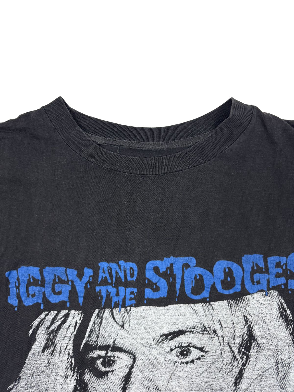 Nahaufnahme des Rundhalsausschnitts des Vintage-Shirts; zeigt die Textur des Baumwollstoffs und den leicht verwaschenen Zustand.