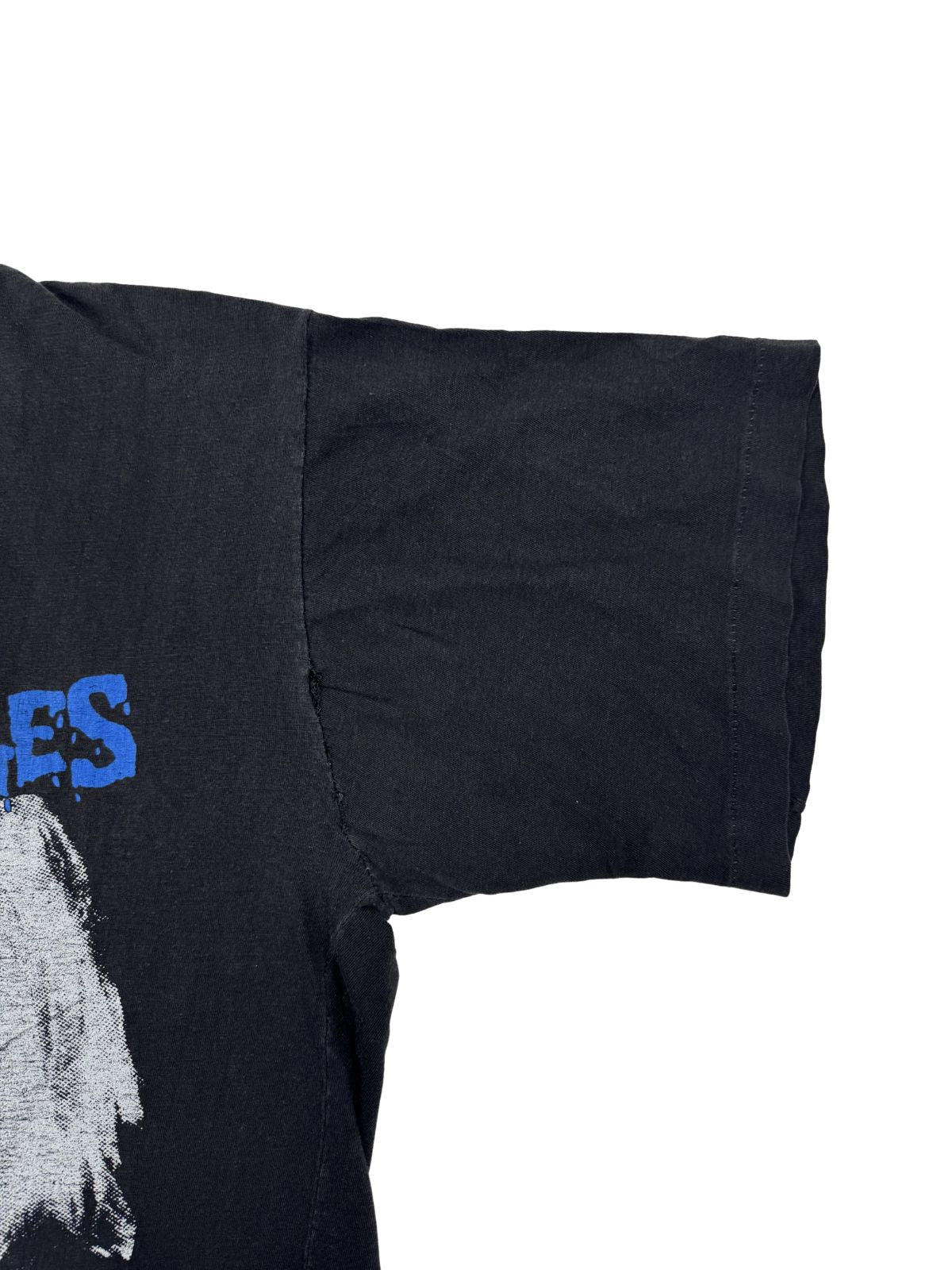 Detailaufnahme des Ärmelsaums mit sichtbarer „Single Stitch“ Naht und der verwaschenen (gebrochenen) schwarzen Stofftextur.