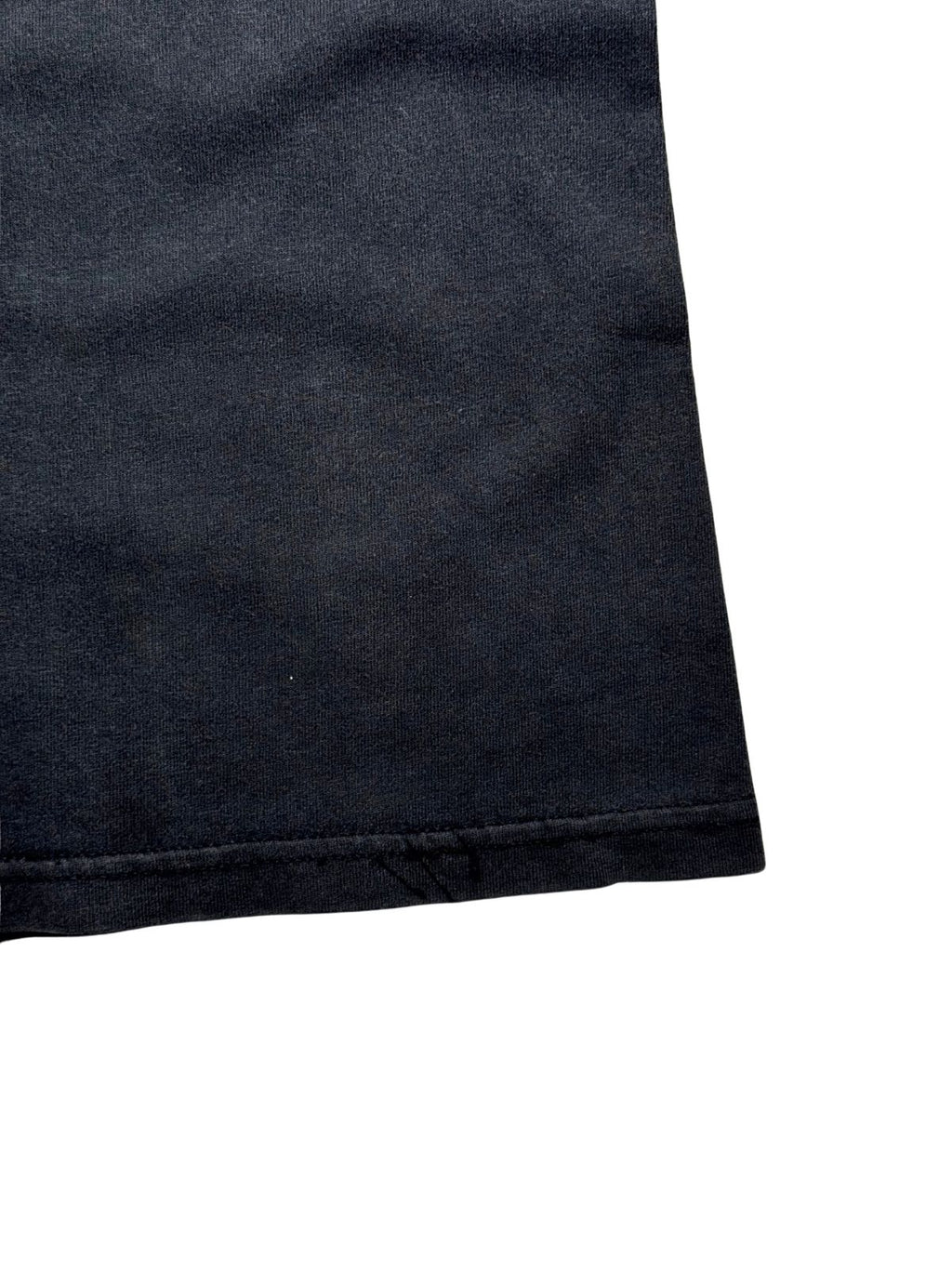 Detailaufnahme der unteren Saumkante mit sauber verarbeiteter Doppelnaht auf dem verwaschenen Shirt.