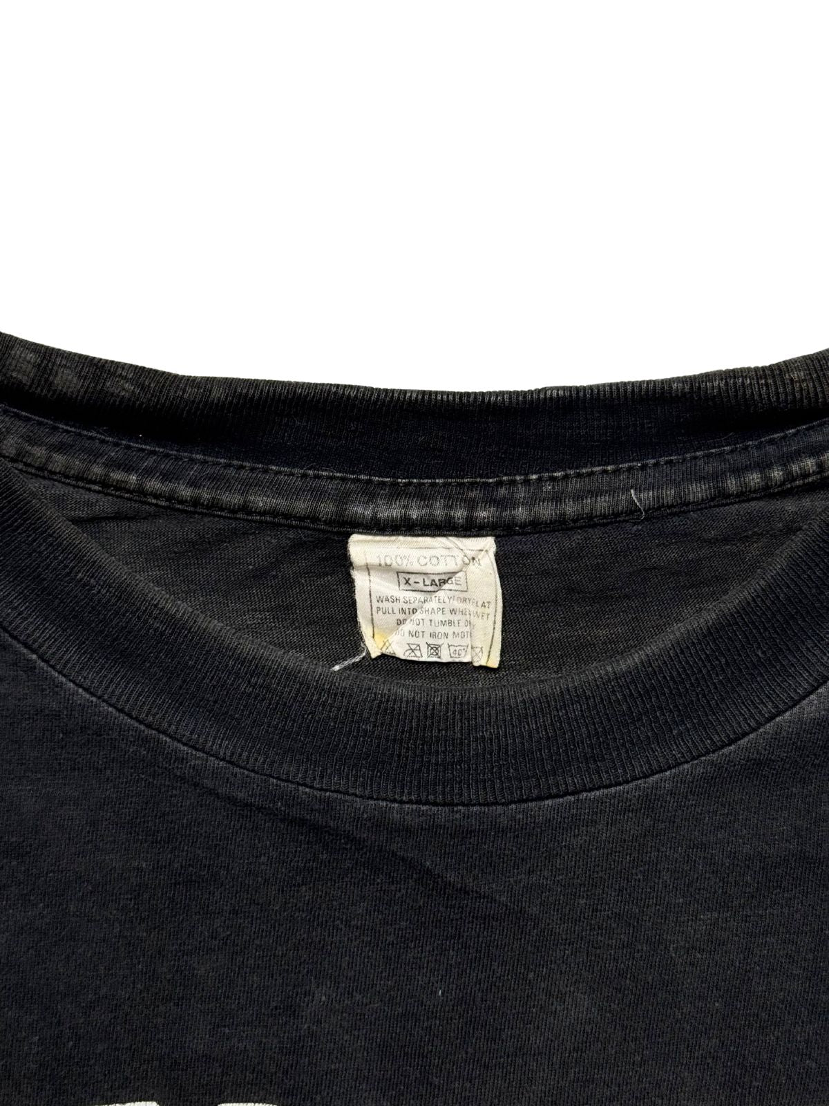 Makroaufnahme des gerippten Kragens mit dem originalen weißen Pflegeetikett aus Baumwolle (100% Cotton / X-LARGE) inklusive Waschanleitung.