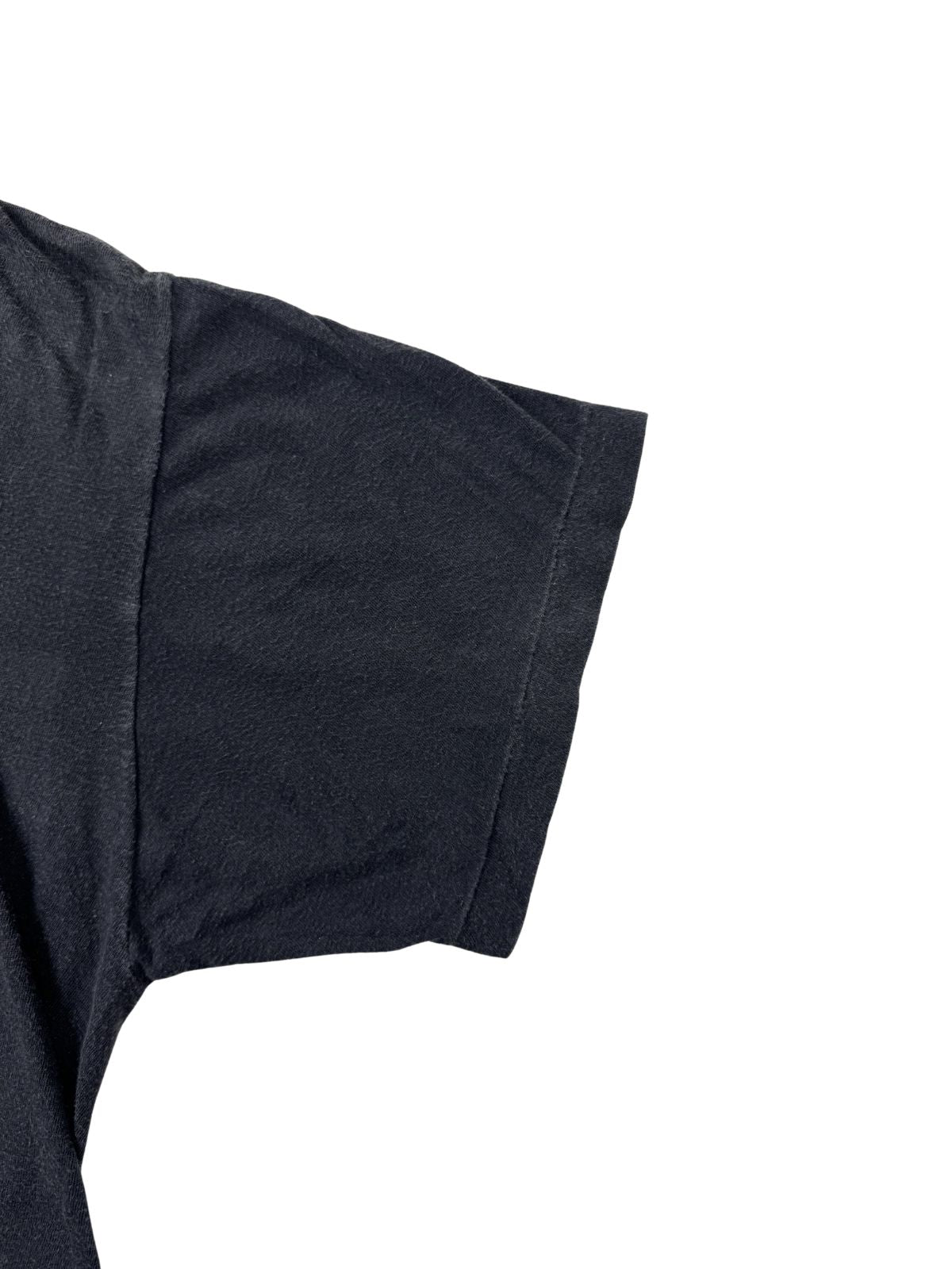 Nahaufnahme des Ärmelsaums eines verwaschenen schwarzen Iron Maiden Vintage T-Shirts; zeigt die authentische „Single Stitch“ Naht (Einzelnaht), typisch für Originale aus dem Jahr 1984.